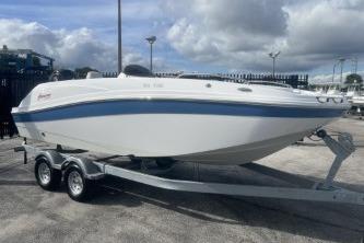 2022 Hurricane SunDeck 192 OB boat on trailer under cloudy sky.