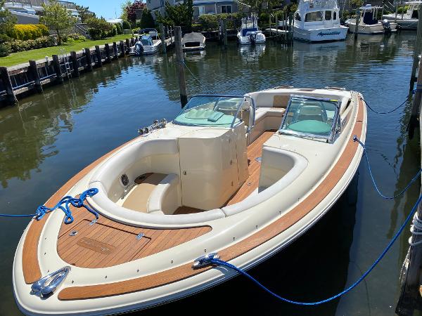 2014 Chris-Craft Launch 28 boat docked in a marina, featuring elegant wood detailing.
