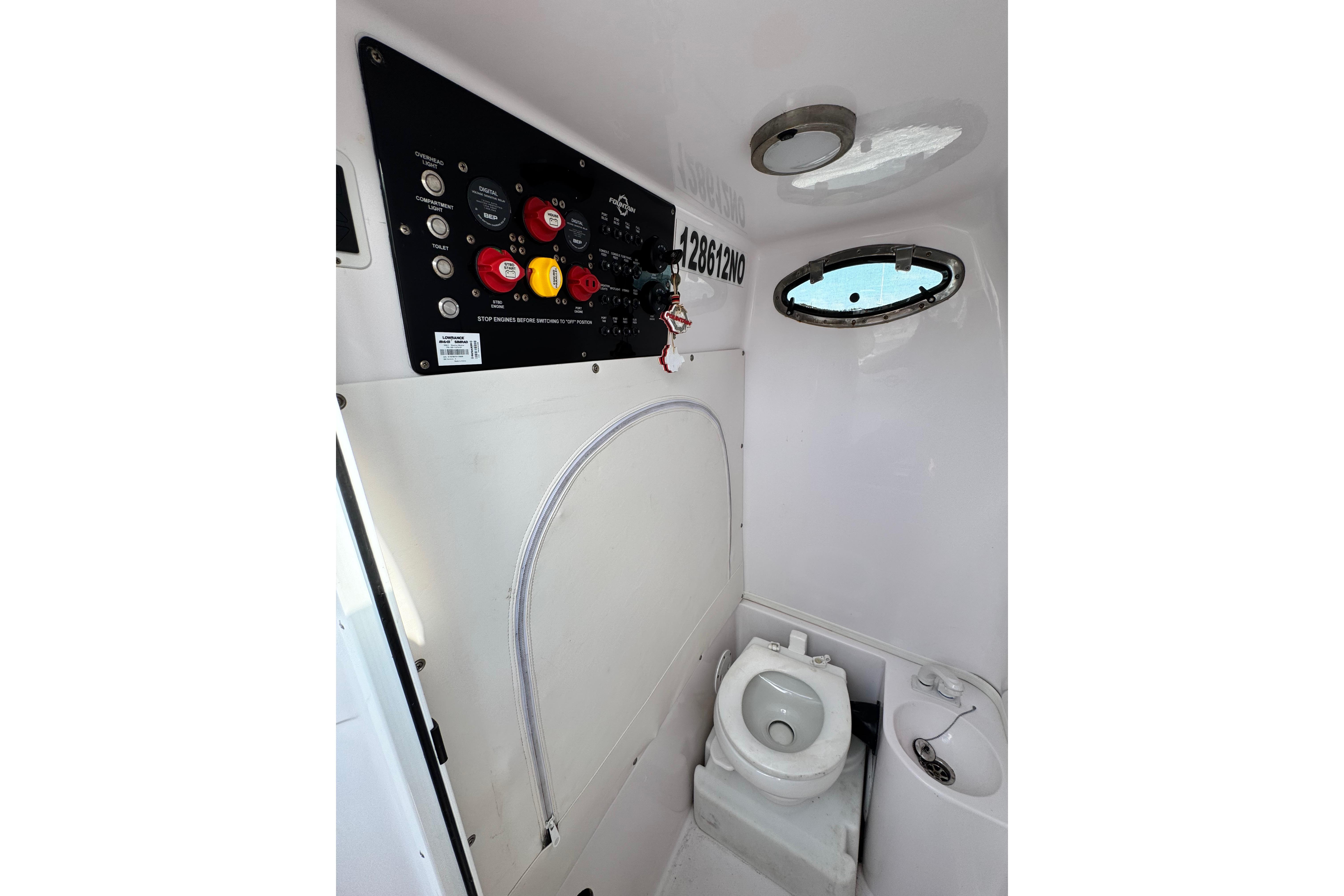 Interior of 2018 Fountain 34 Center Console boat with control panel and marine toilet.