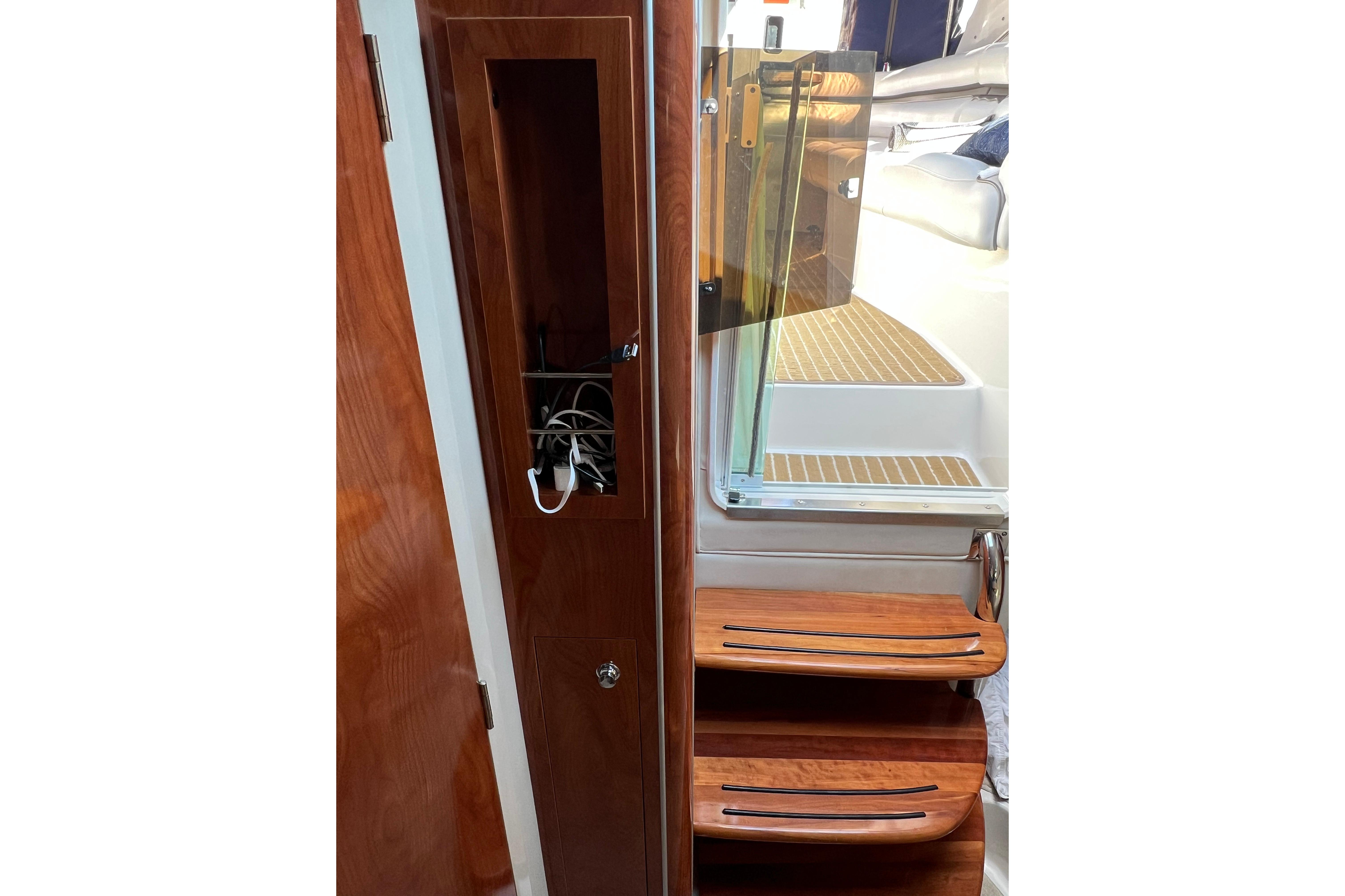 Interior of 2011 Doral 28 Prestancia boat with wooden steps and storage compartment.