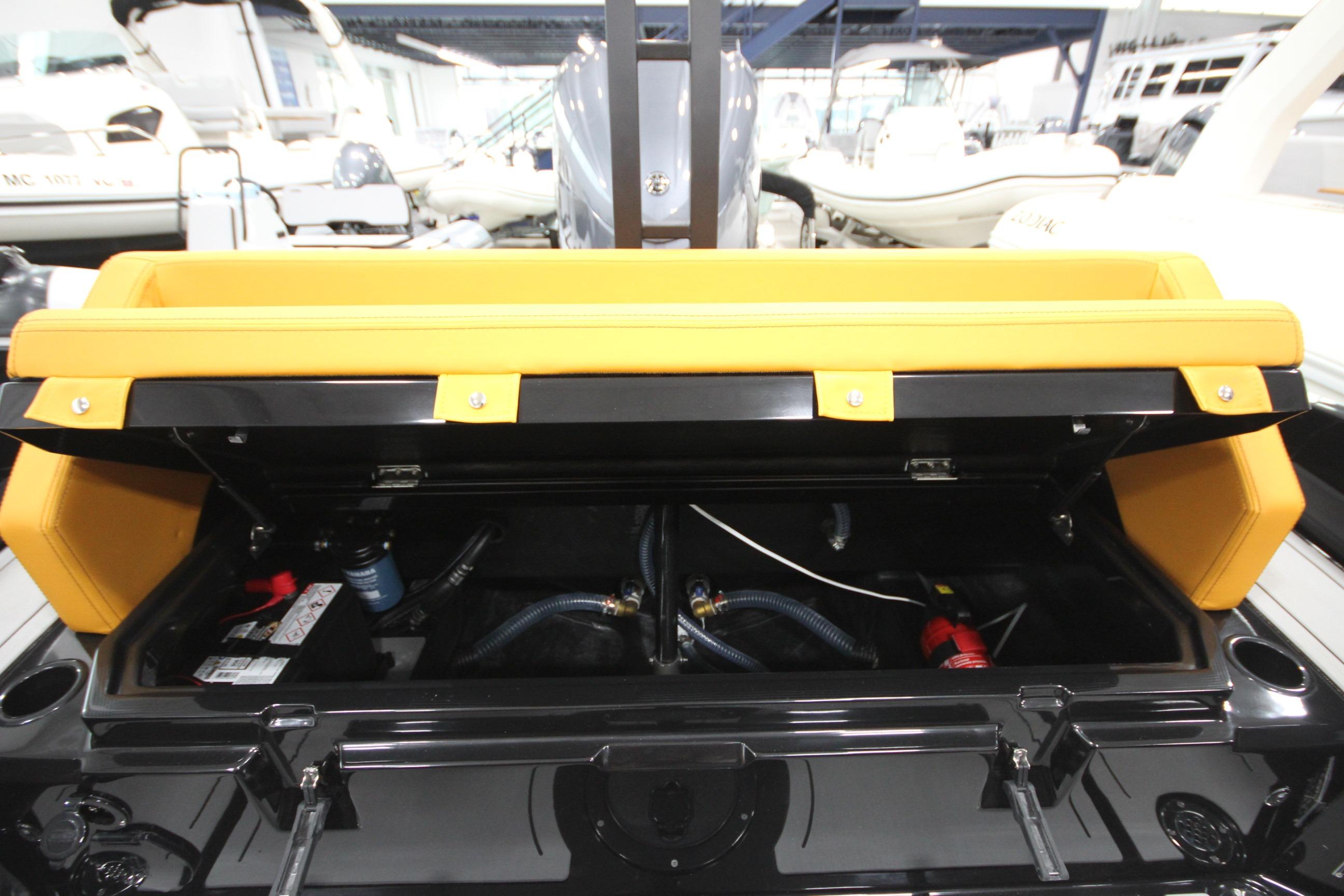 Open storage compartment of Iron 767 boat, showcasing internal components and yellow seating.