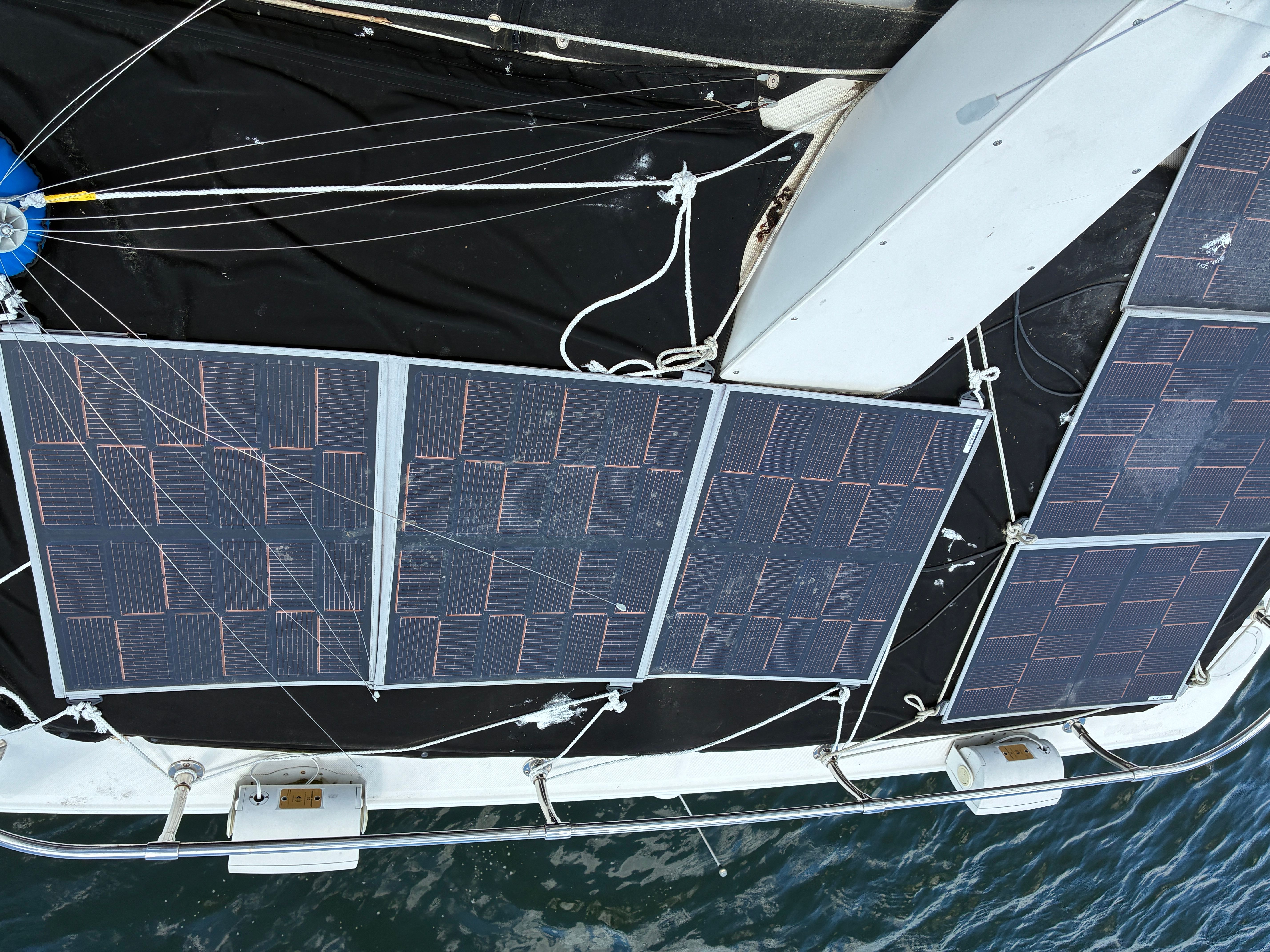 Solar panels on a boat, mounted on the deck, with water in the background.