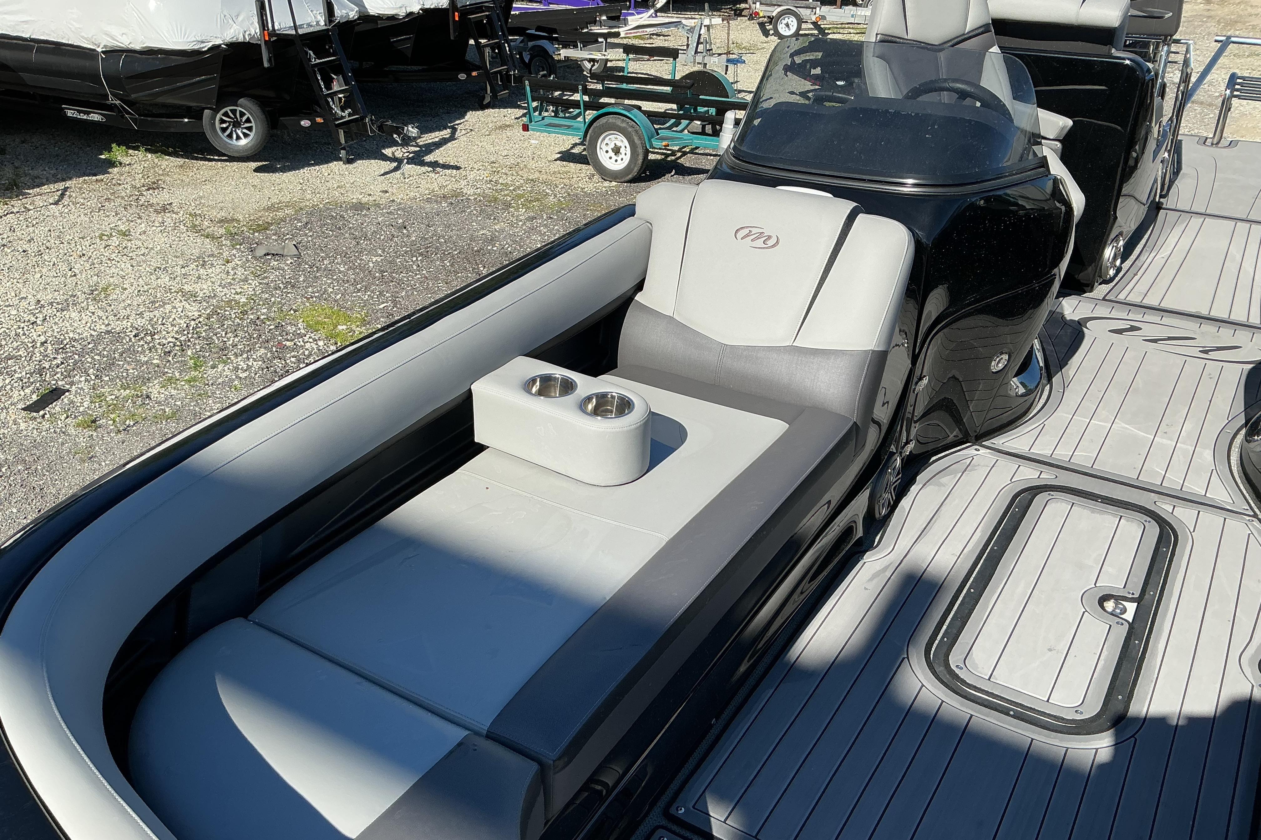 2024 Manitou 25 X-Plode XT SRS boat interior with gray seating and cup holders.