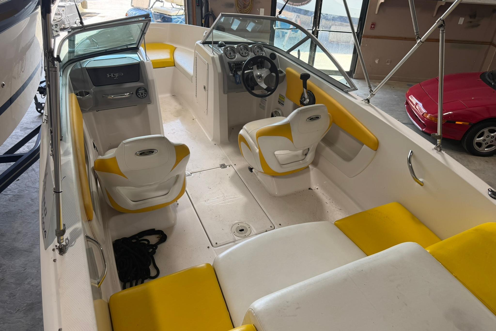 2012 Chaparral 19 Sport H2O boat interior with yellow and white seating, steering console.