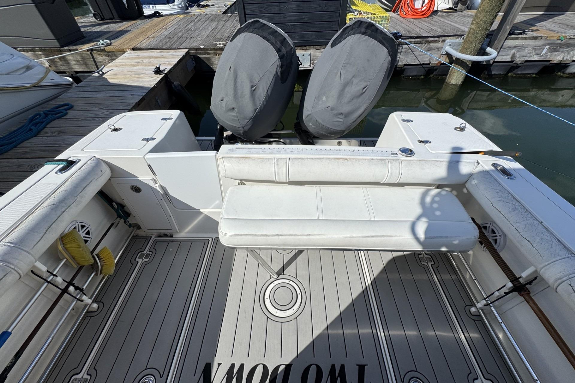 2007 Edgewater 245CC boat interior with covered engines and seating at dock.