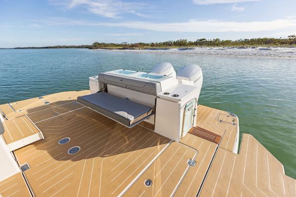 Manufacturer Provided Image: 2026 Regal LX43 boat with spacious deck and seating, near serene waters and sandy shoreline.