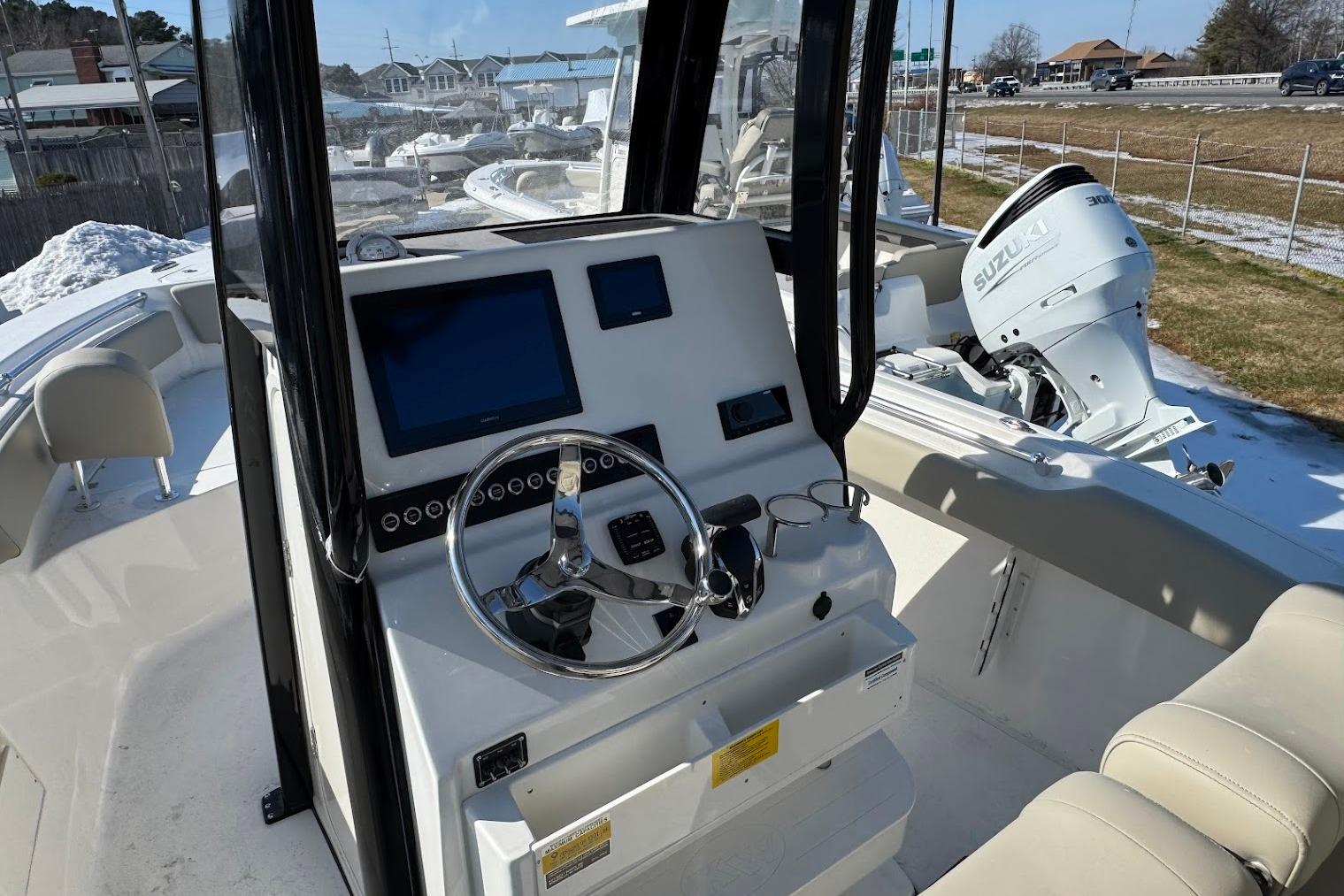 2026 Key West 239 FS boat interior with steering console and Suzuki outboard motor.