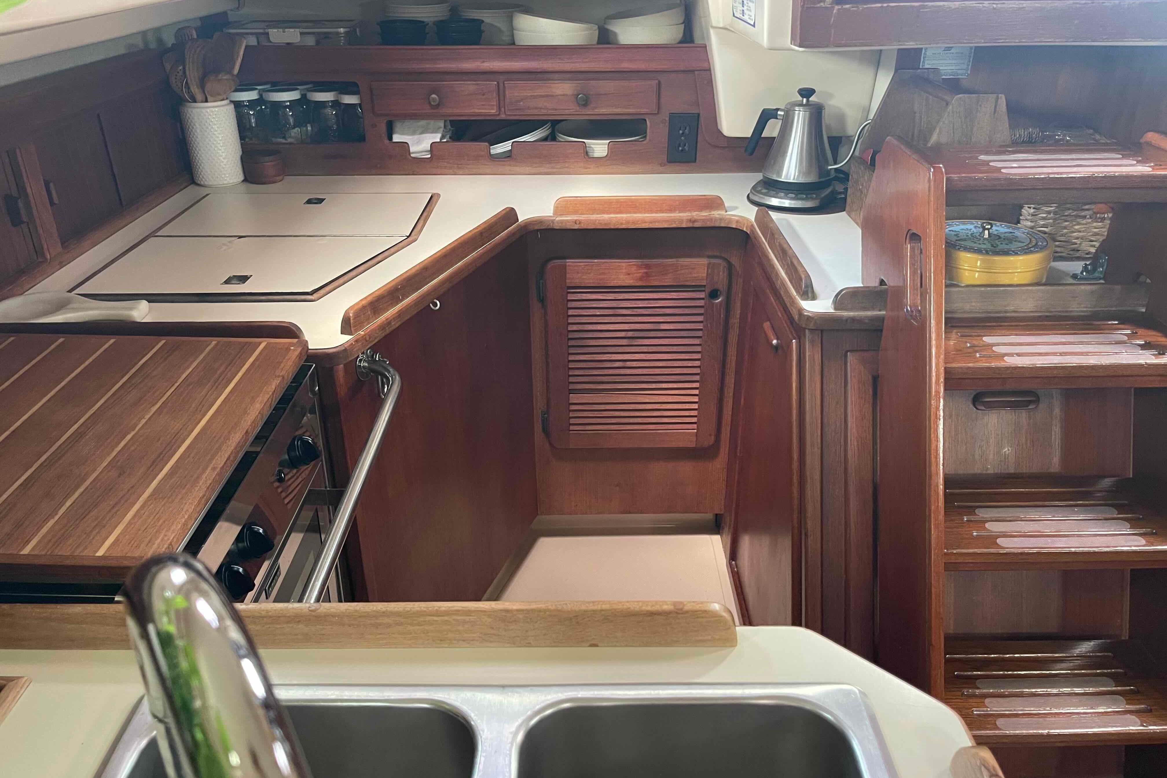 1989 Island Packet 35 yacht interior kitchen with wooden cabinetry and modern appliances.