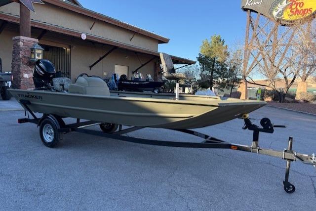 2026 Tracker Grizzly 1754 SC boat on trailer, parked outside a building.