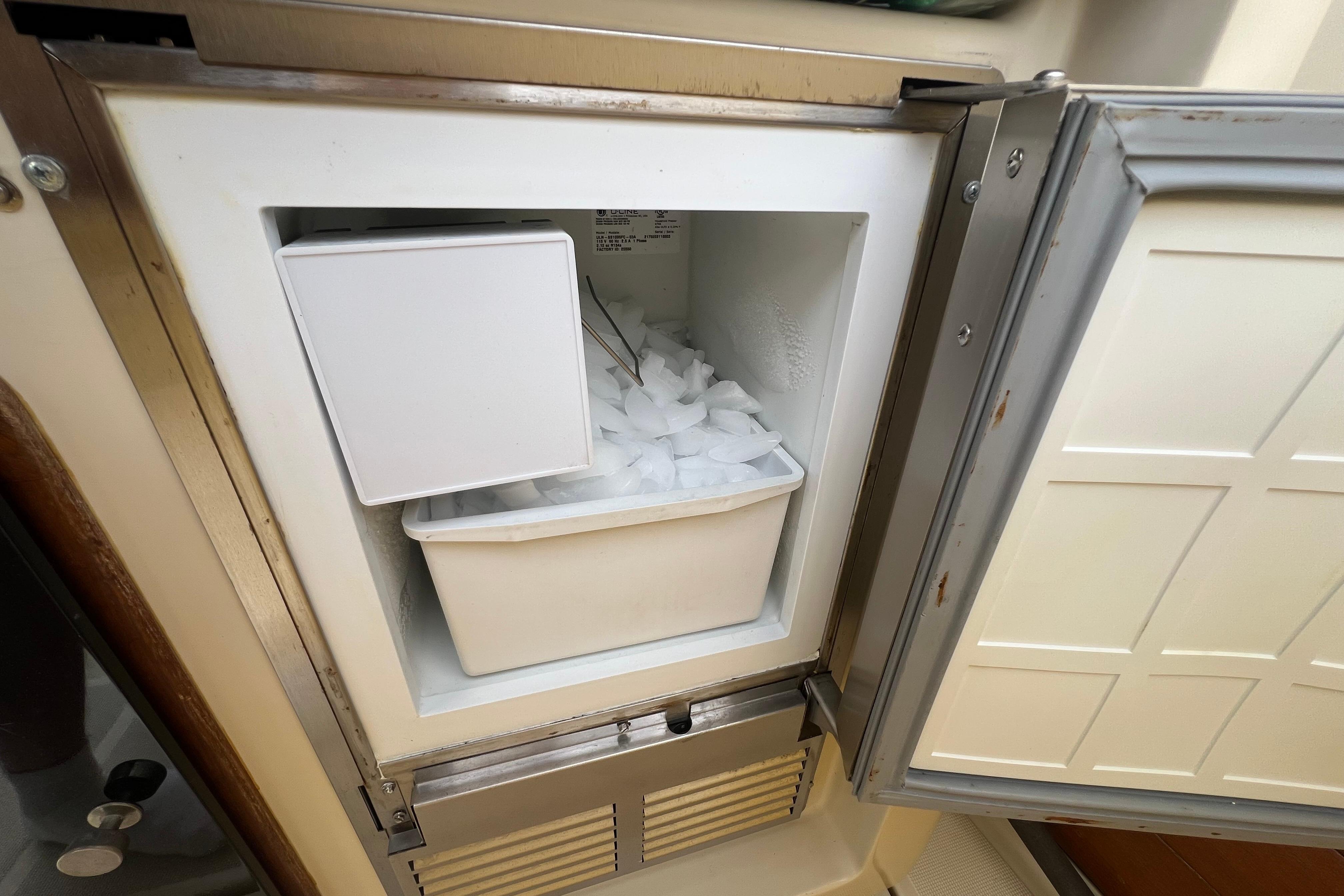 Open freezer with ice bin inside a 1985 Tiara 36 OPEN boat.