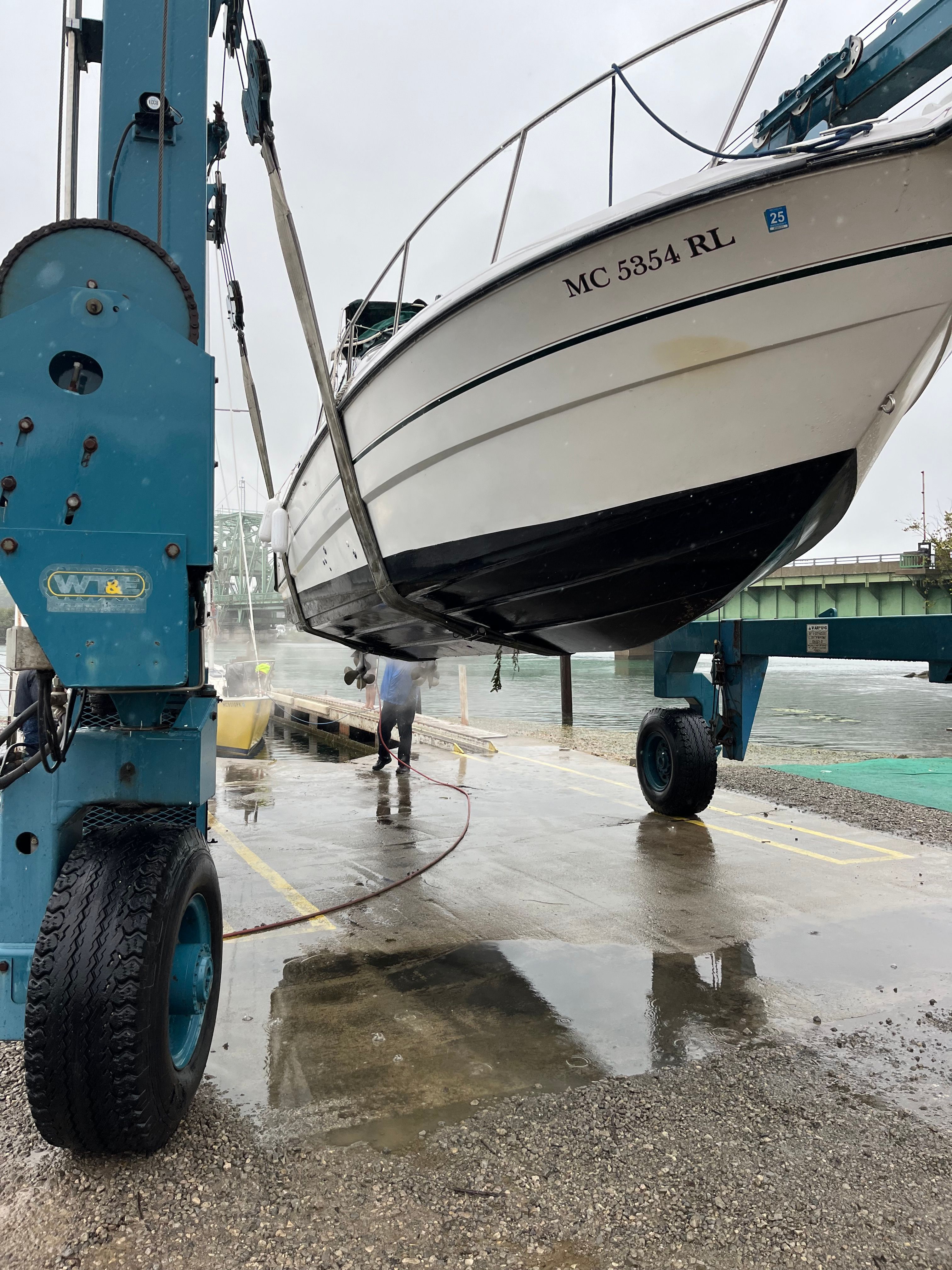 A boat is being lifted out of the water by a crane.