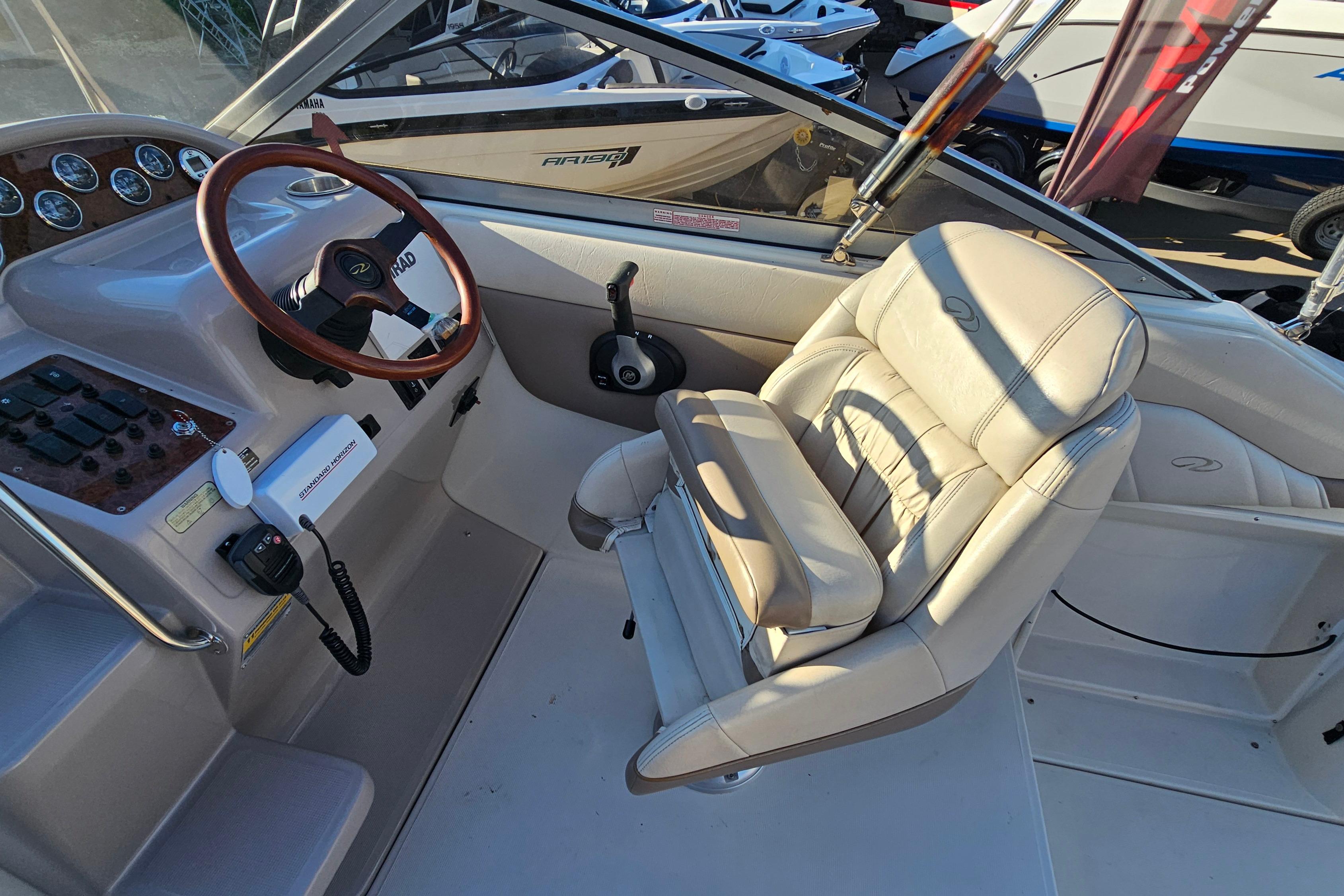 Interior of a 1999 Regal Commodore 258 boat with steering wheel and captain's chair.