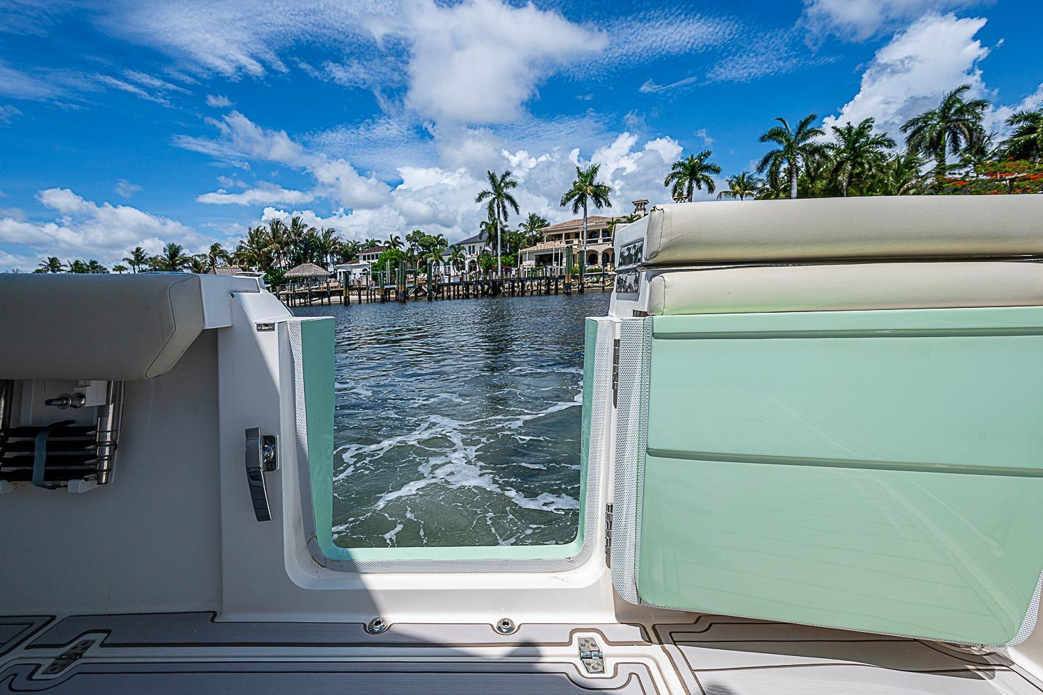2019 Cobia 320 Center Console boat with open side door, scenic waterfront view.