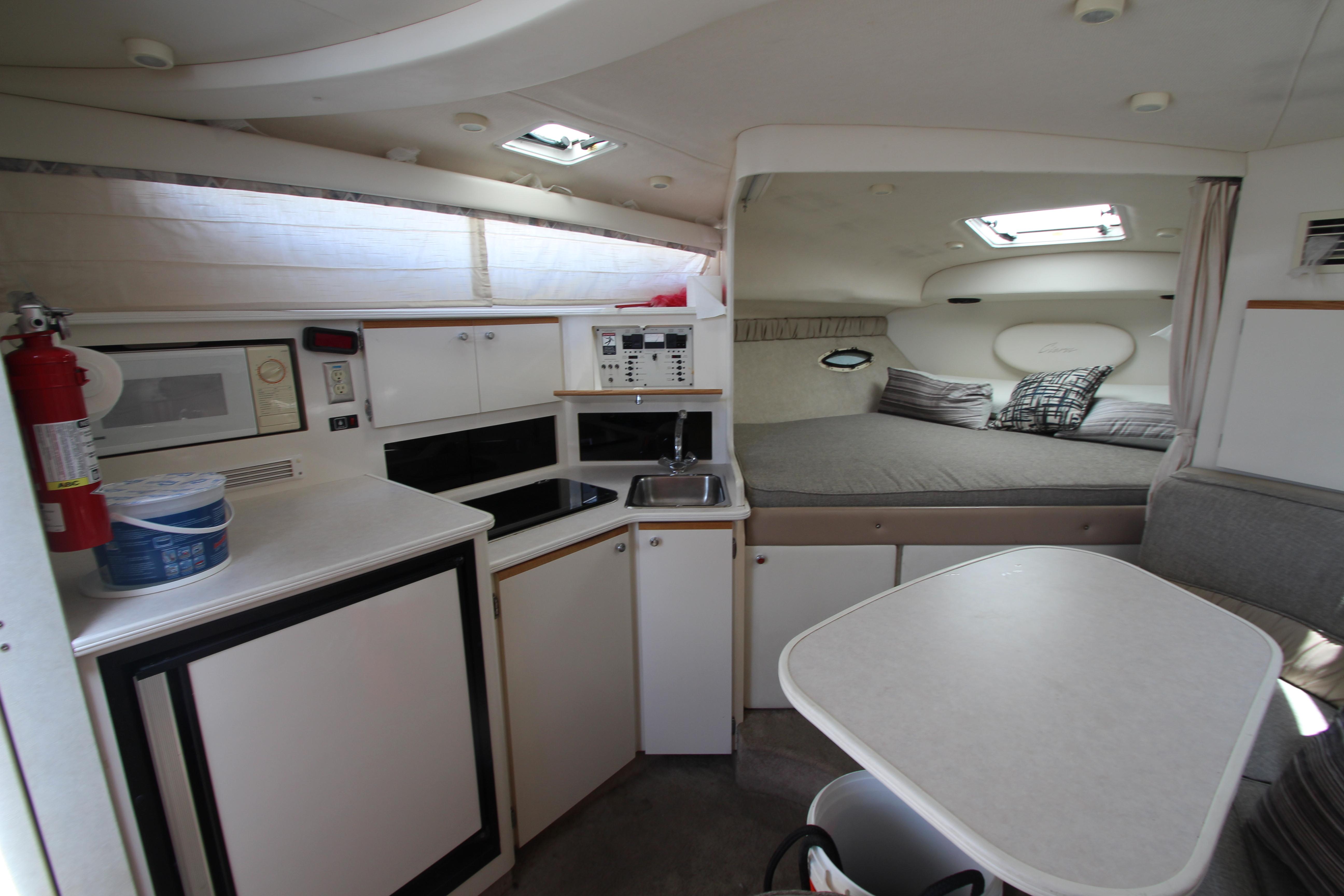 Interior of 1999 Bayliner 3055 Ciera boat with kitchenette, dining area, and sleeping quarters.