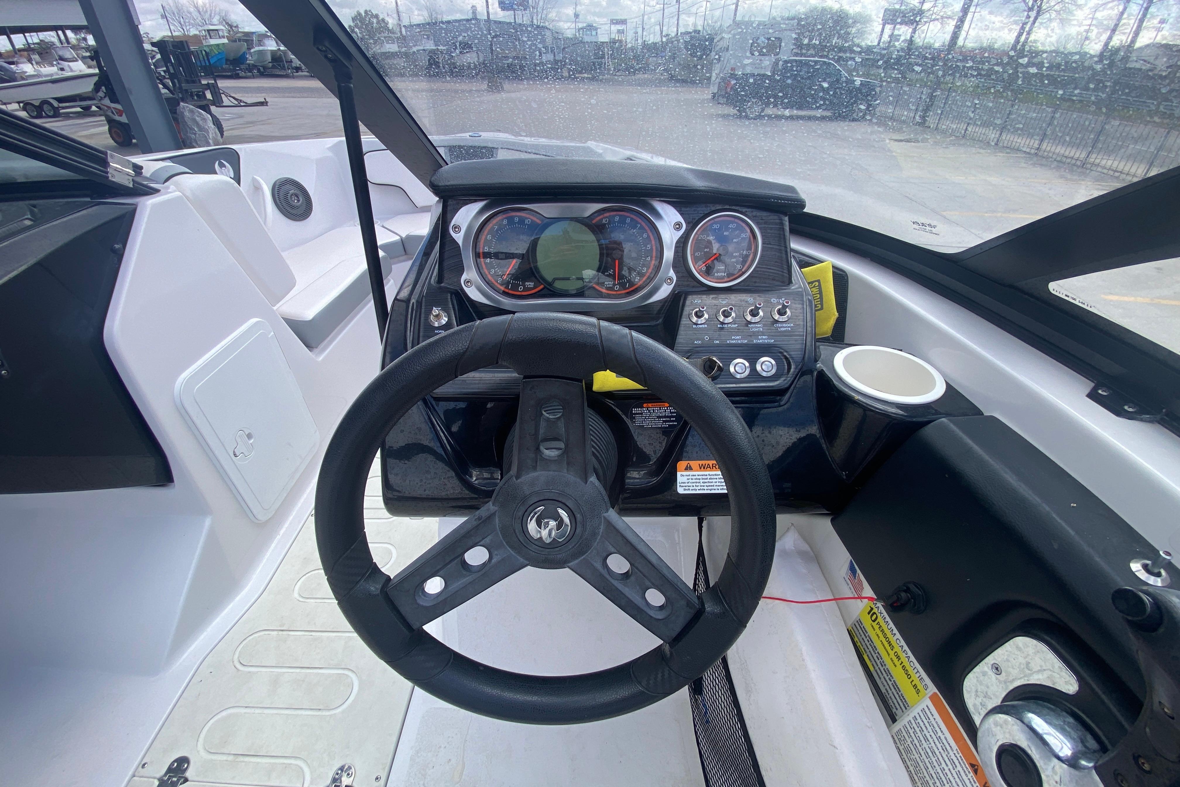 Cockpit view of 2018 Scarab 215 G boat with steering wheel and dashboard controls.