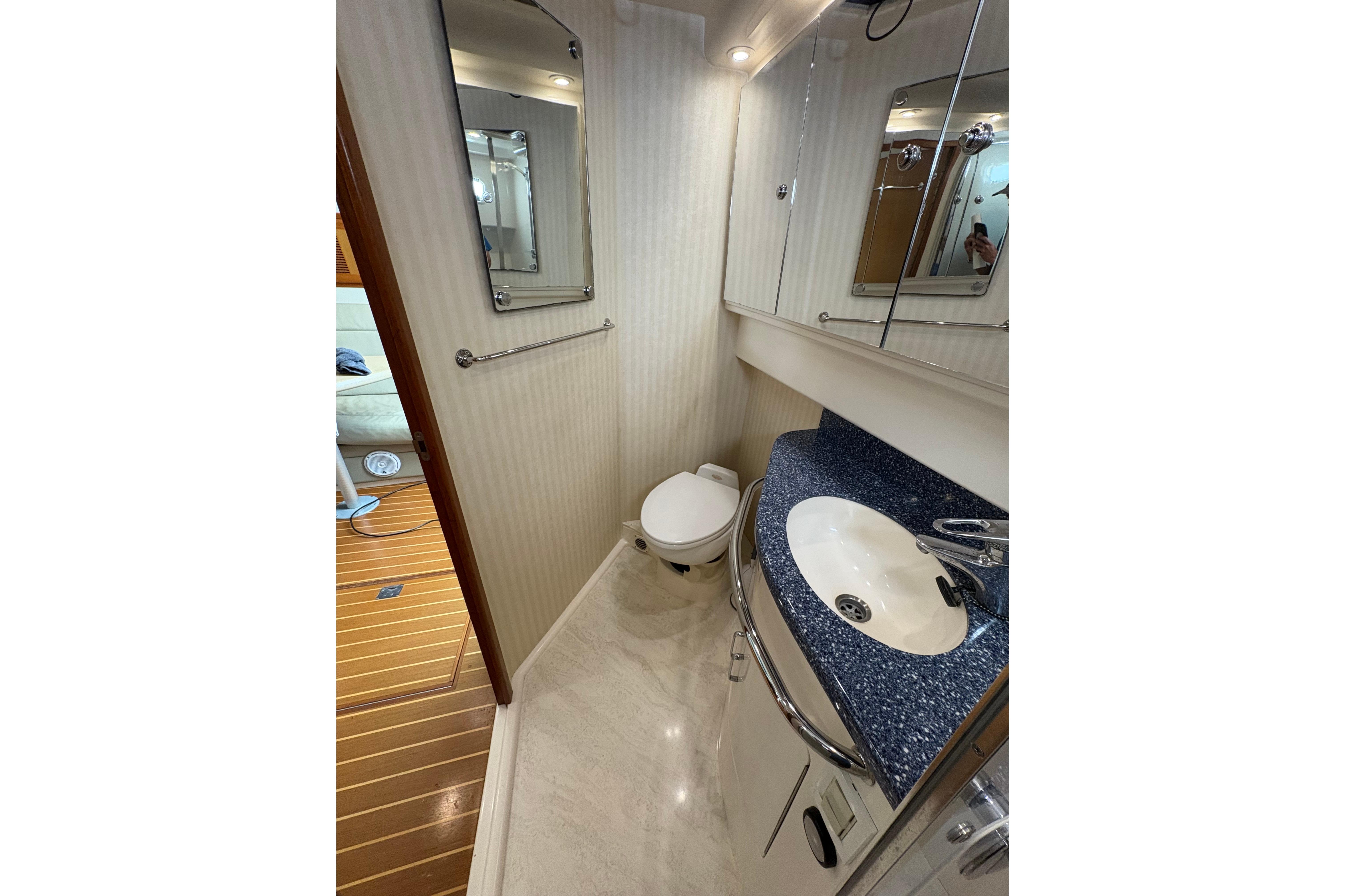 Bathroom interior of 2004 Cabo 40 Hardtop Express yacht, featuring sink and toilet.