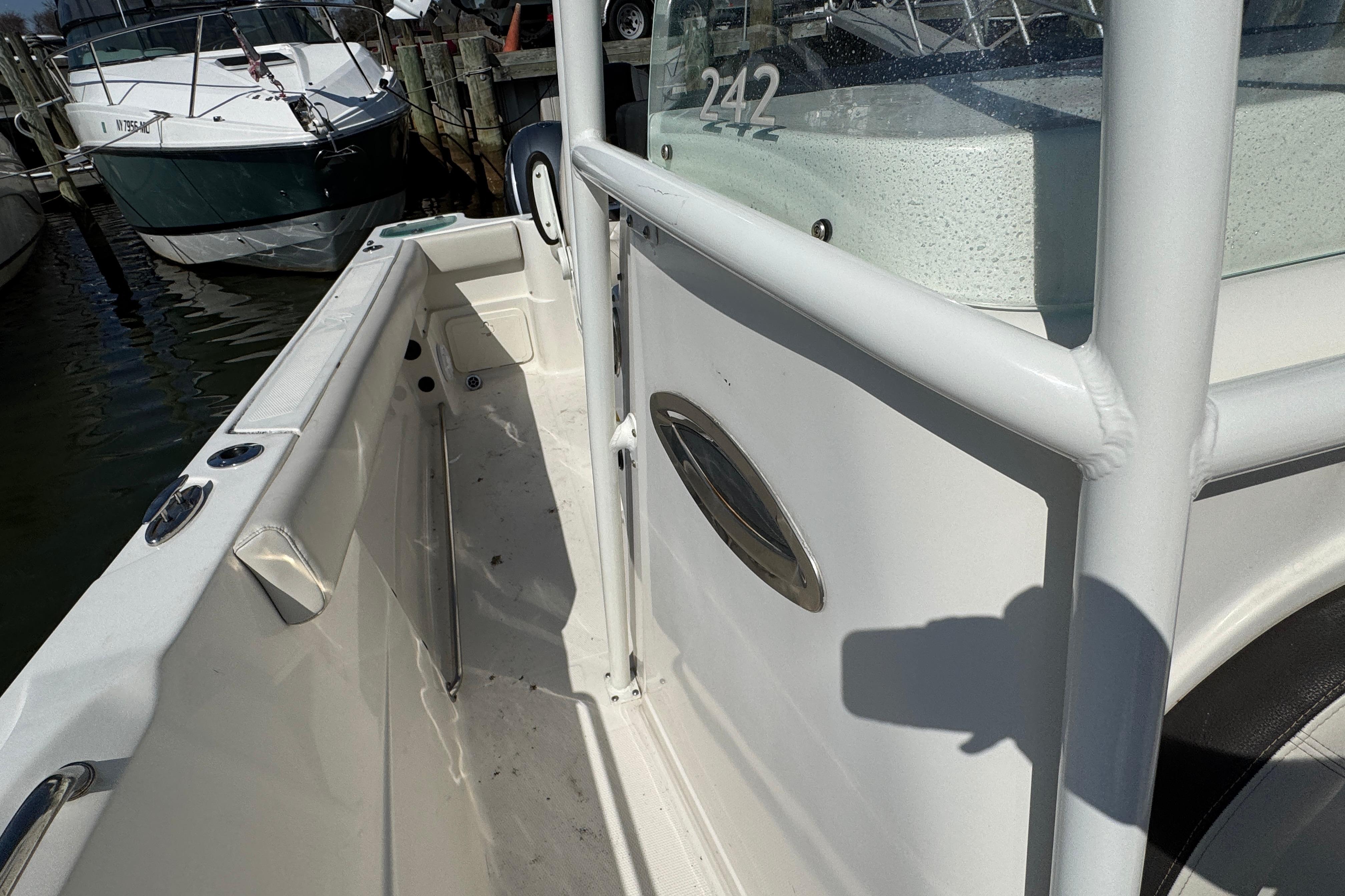 2022 Sailfish 242 CC boat docked, showcasing sleek white interior and sturdy railings.