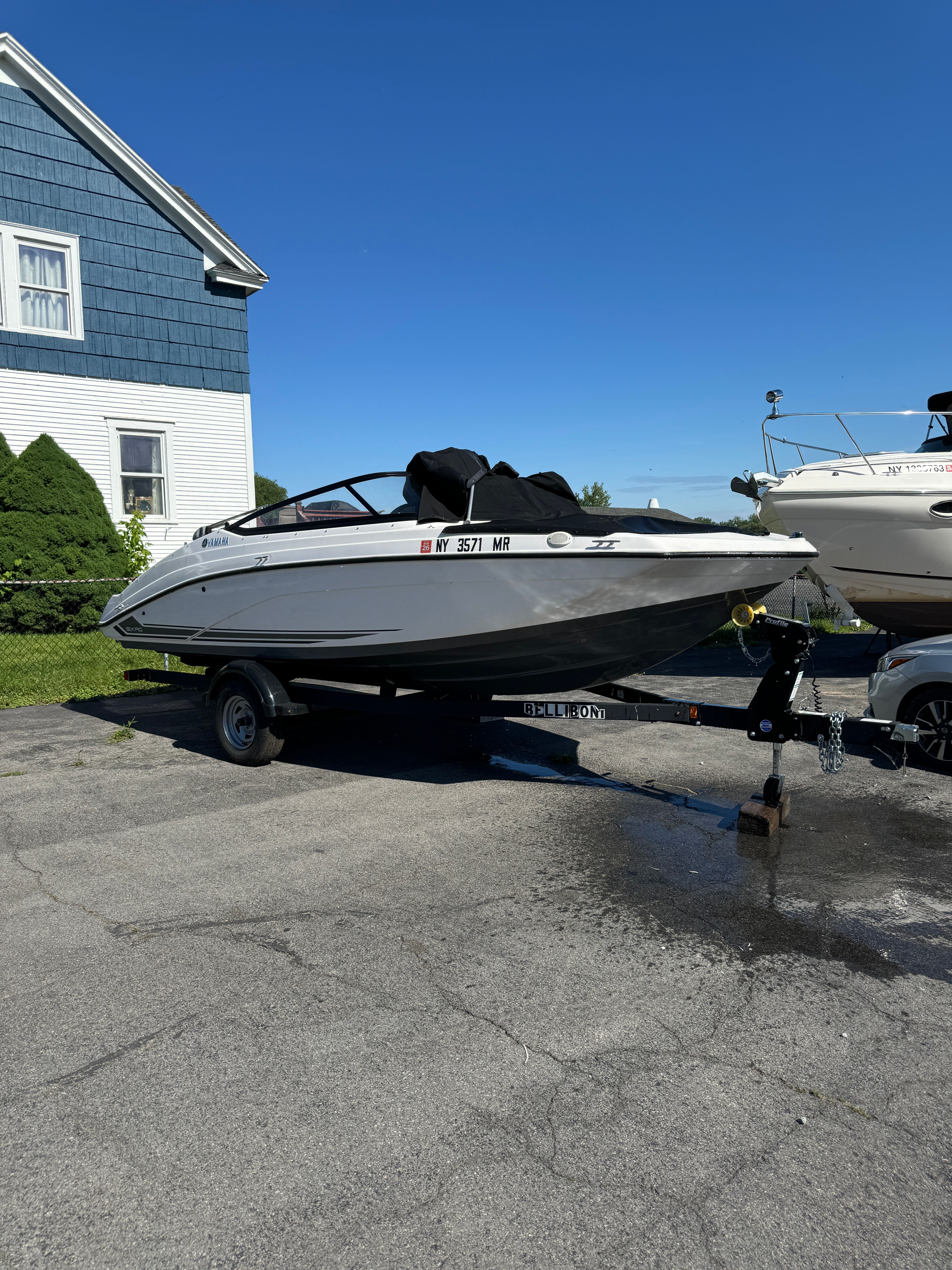 2020 Yamaha SX190 boat on trailer in front of blue house.