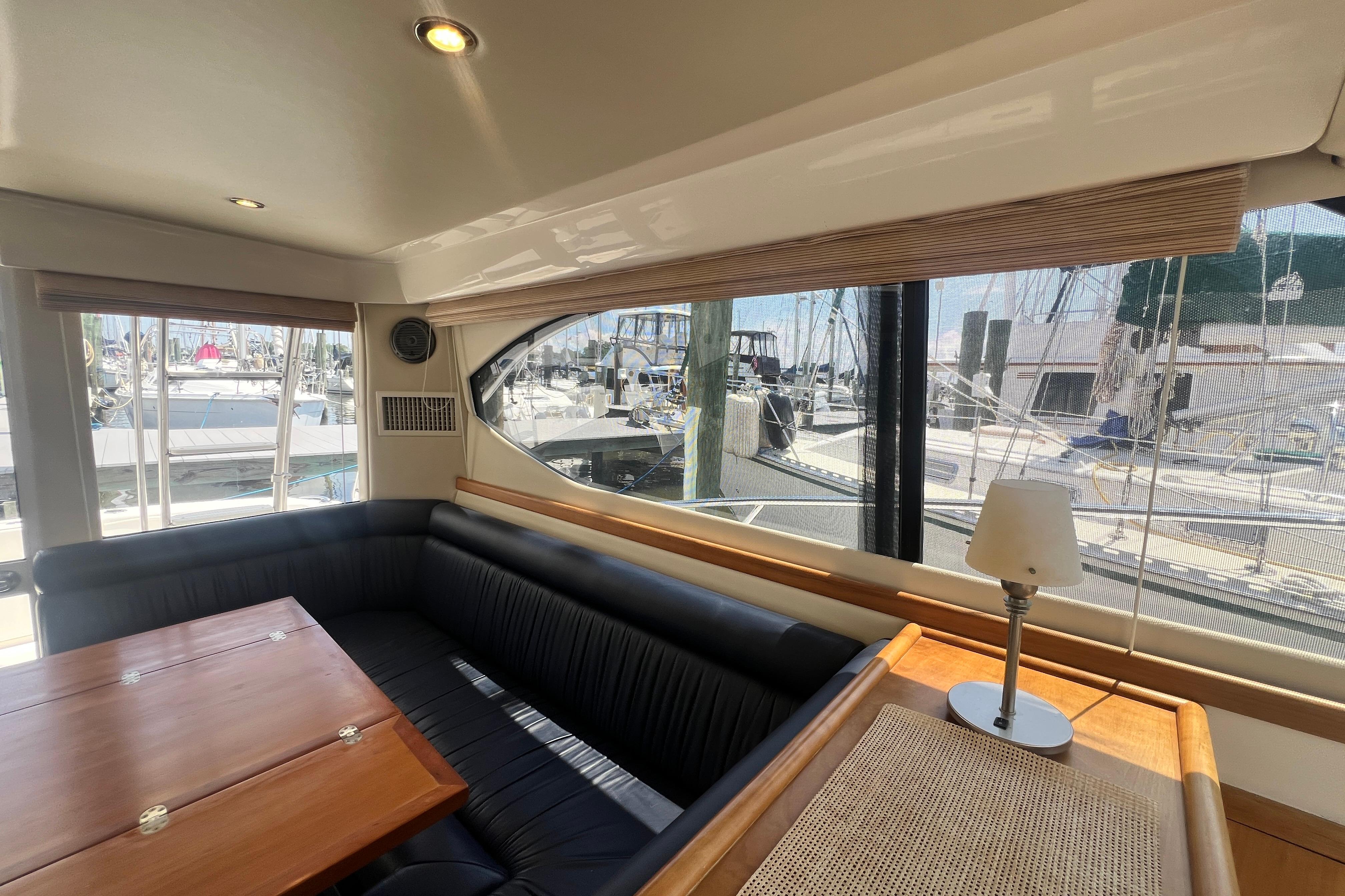 Interior of 2007 Riviera 33 Flybridge yacht with elegant seating and marina view.