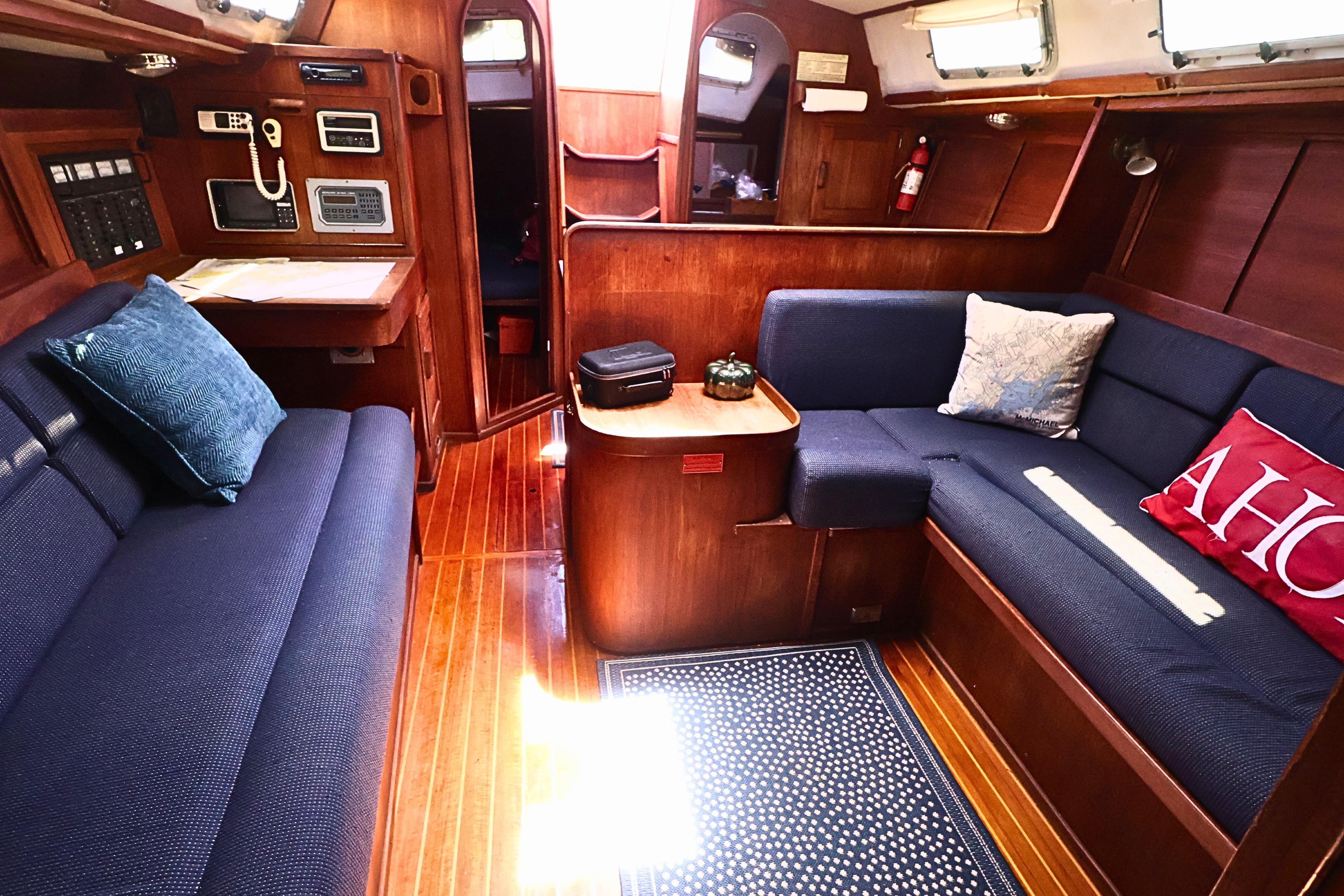 1989 J Boat J 40 interior with wooden finish, blue seating, and nautical decor.