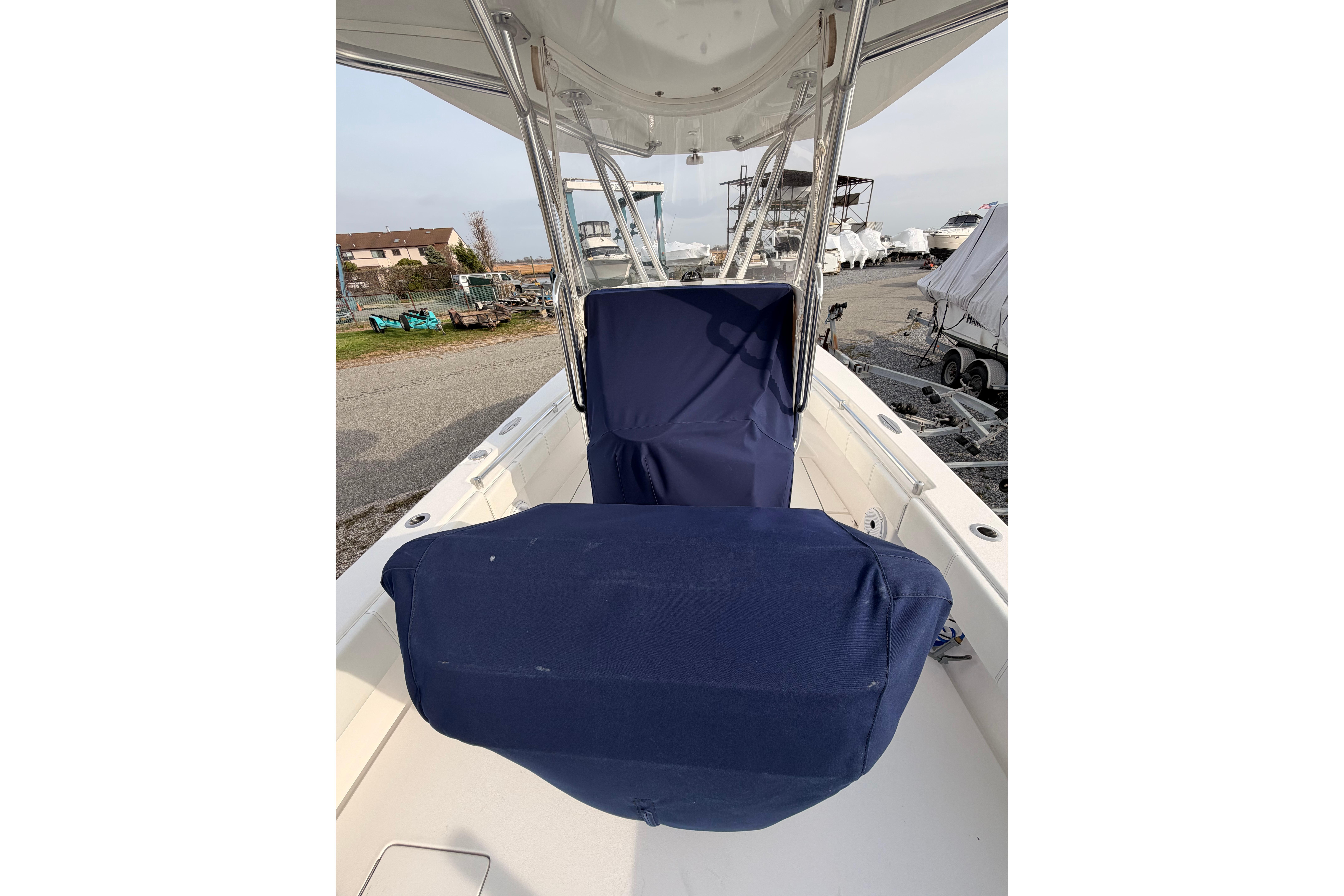 Contender boat with blue seat covers, docked in a marina.