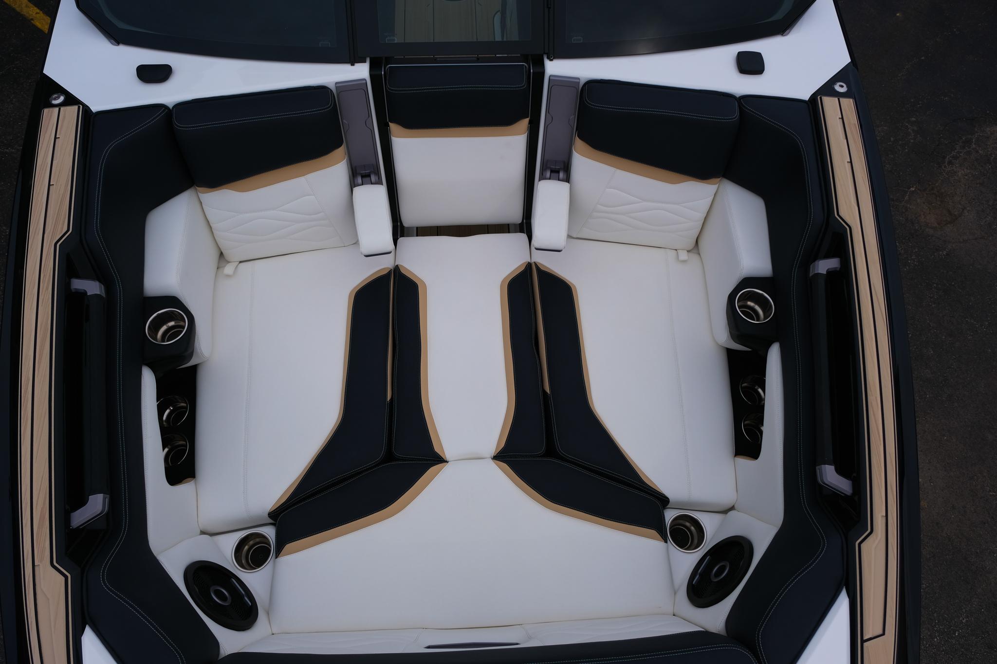 2025 Supra SE450 boat interior with luxurious black and white seating and integrated speakers.