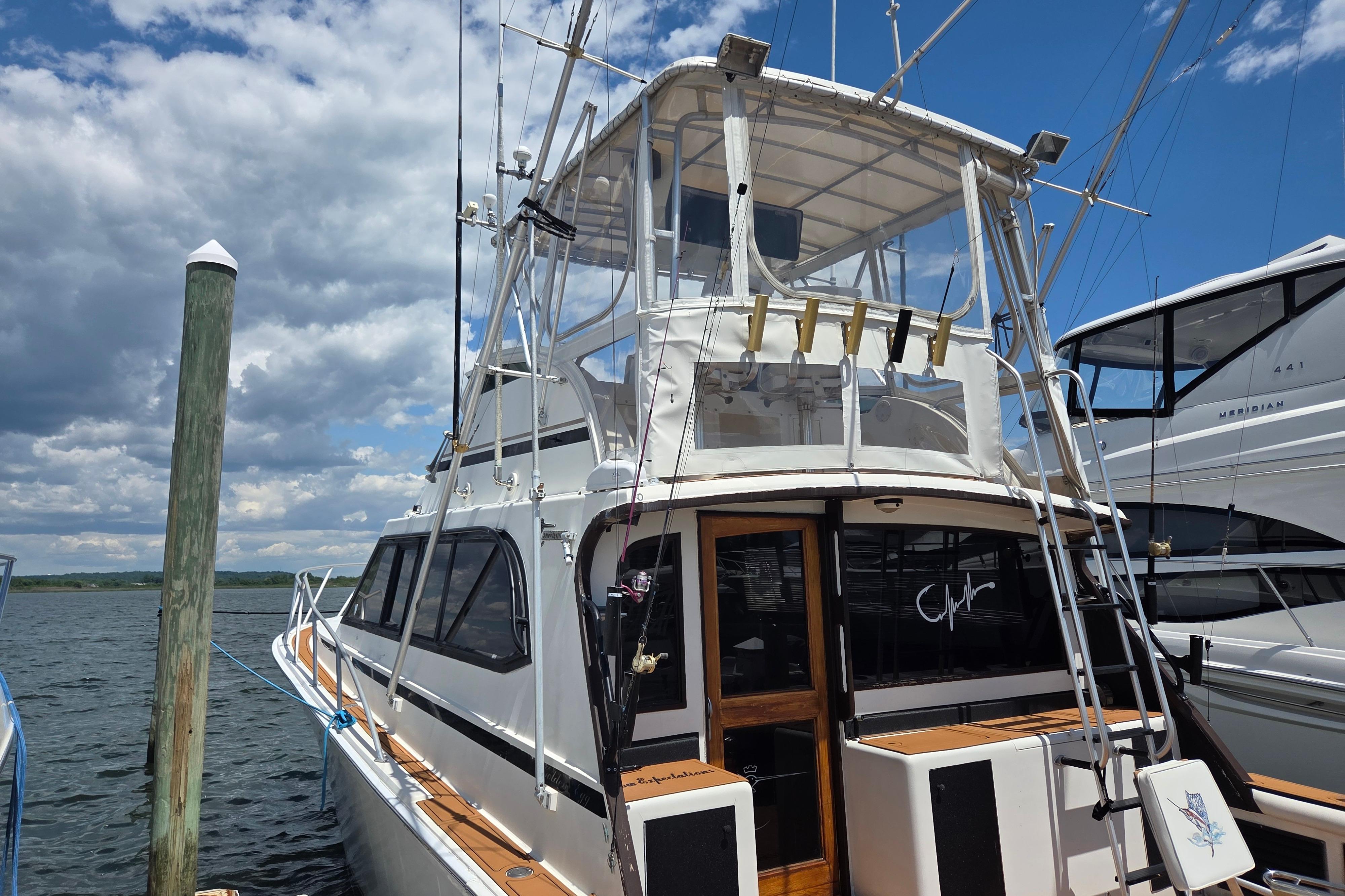 1990 Egg Harbor Golden Egg 42 yacht docked under a partly cloudy sky.