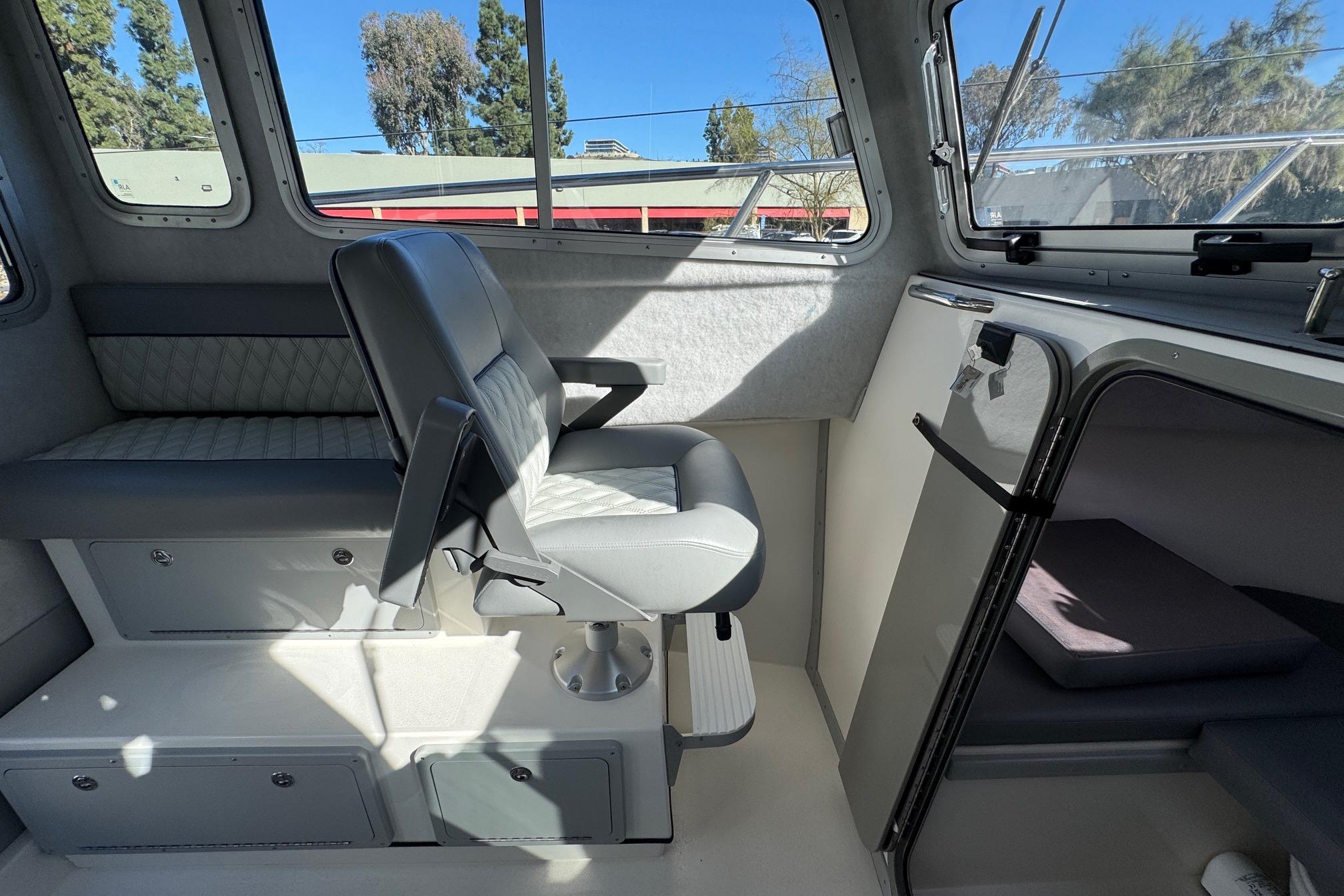 Interior of 2026 Defiance Admiral 250 EX boat, featuring seating and cabin area.