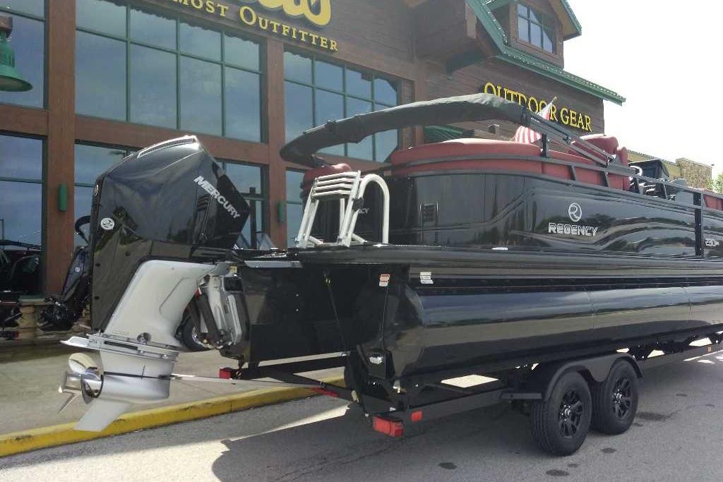 2026 Regency 230 DL boat on trailer outside outdoor gear store.