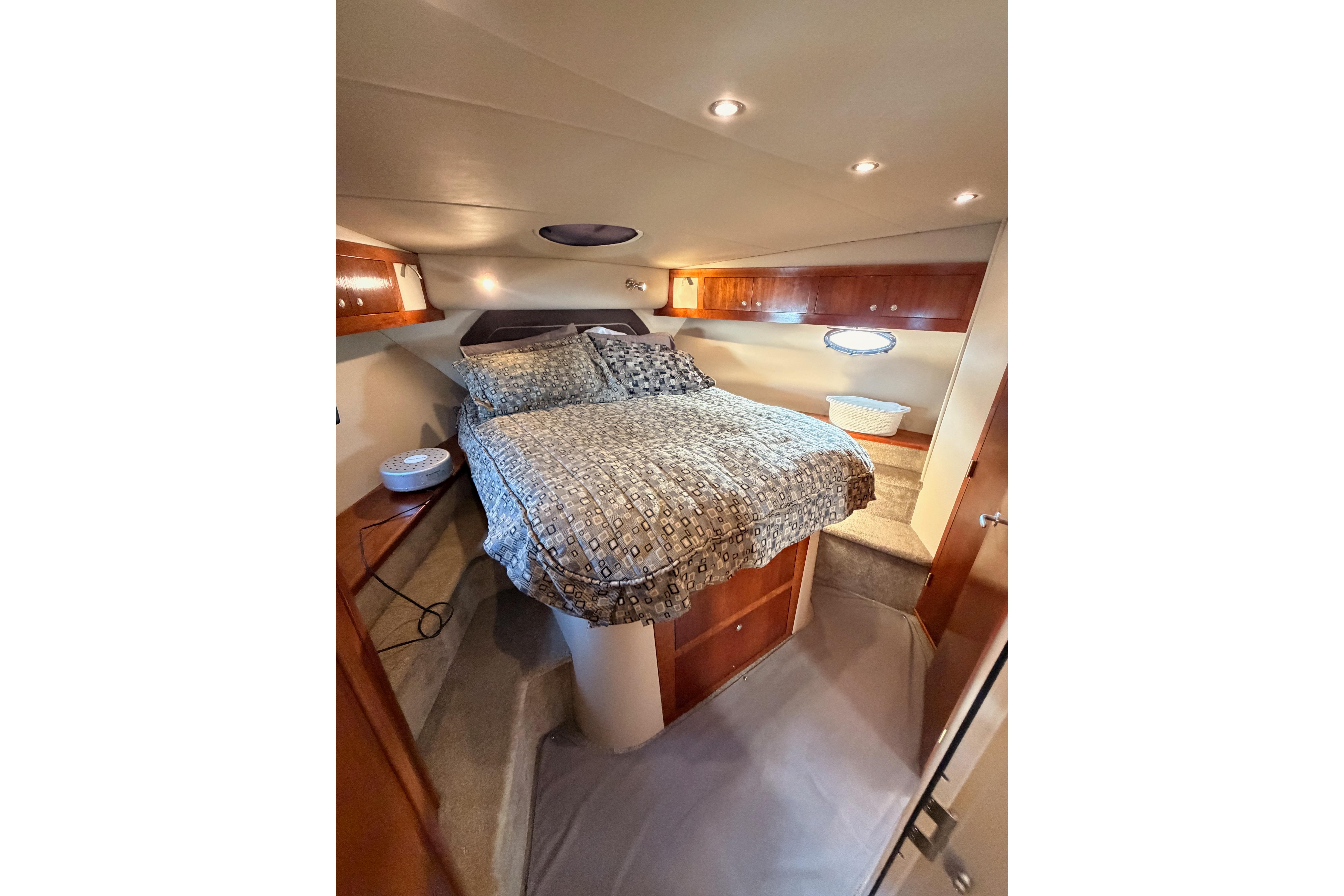 Luxurious bedroom interior of 2005 Cruisers Yachts 405 Express Motoryacht with cozy bedding.