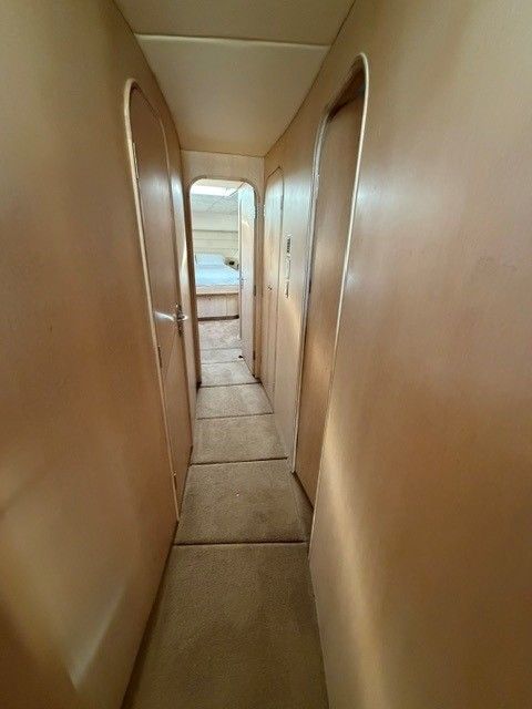 Interior of a 1990 custom motor yacht, narrow carpeted hallway.