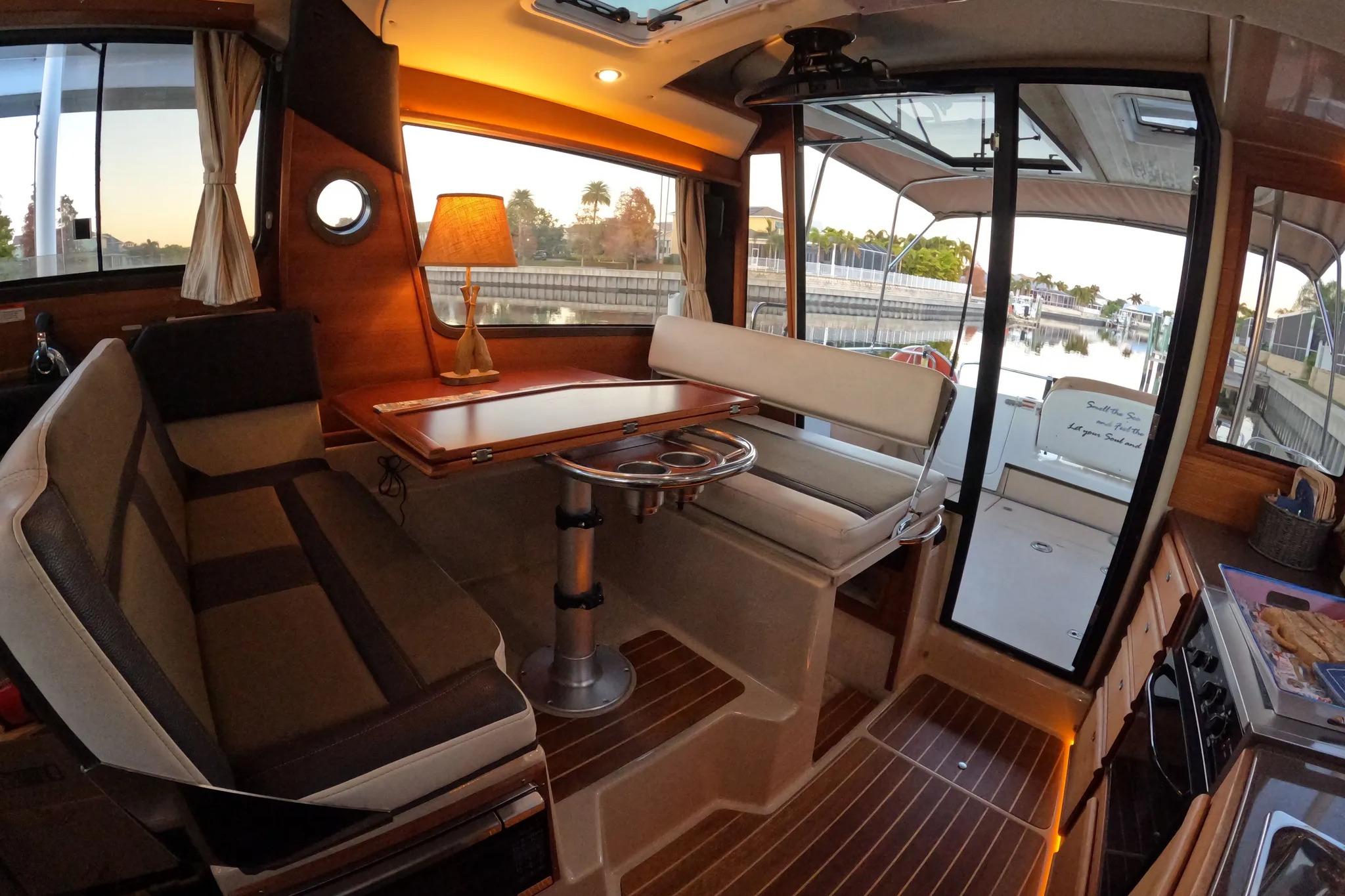 Interior of 2015 Ranger Tugs R-29 S boat with cozy seating and elegant wood finishes.