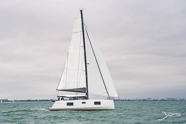 2025 Nautitech 40 Open catamaran sailing on calm waters under cloudy skies.