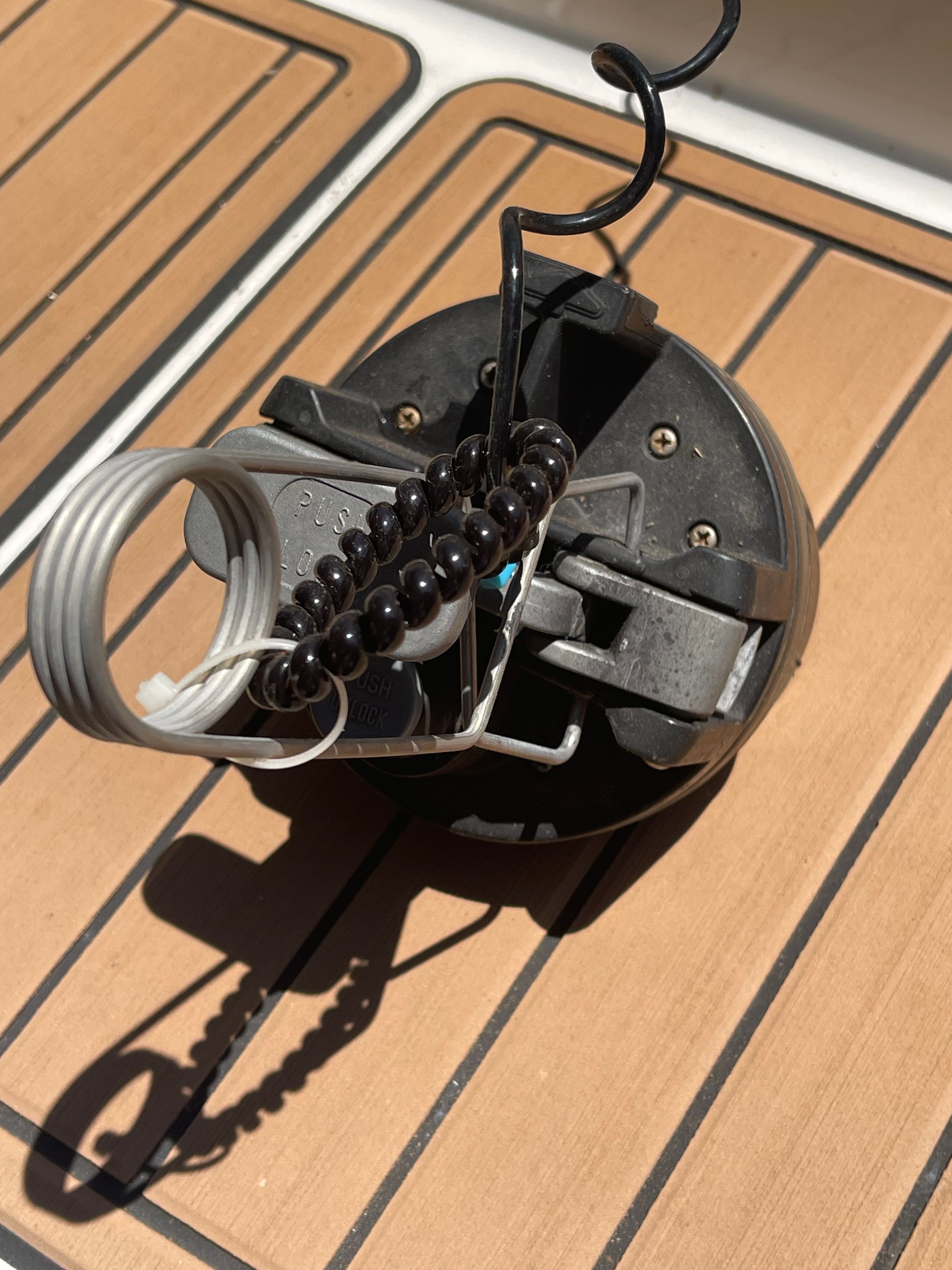 Close-up of a boat accessory on a wooden deck.