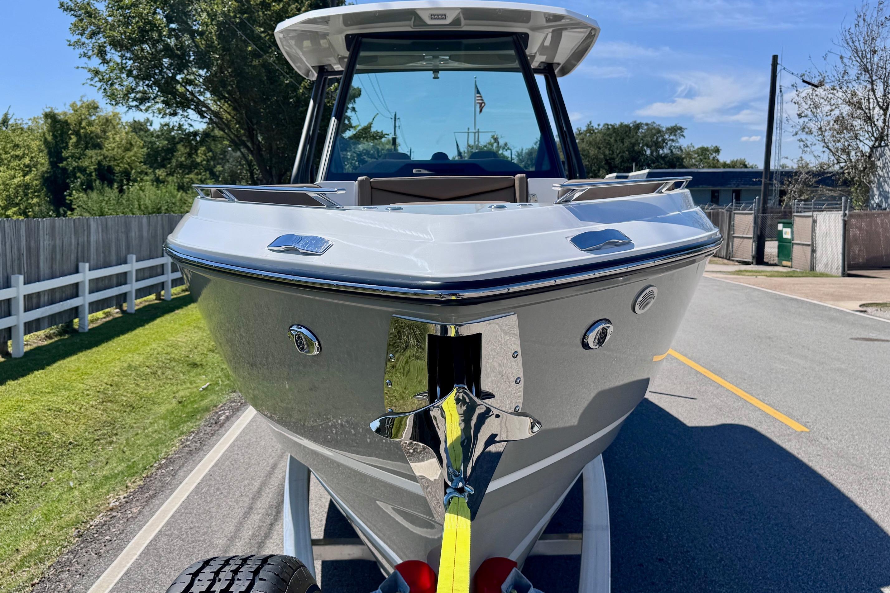 2026 Monterey Elite 27 OB boat on trailer, parked on a sunny road.