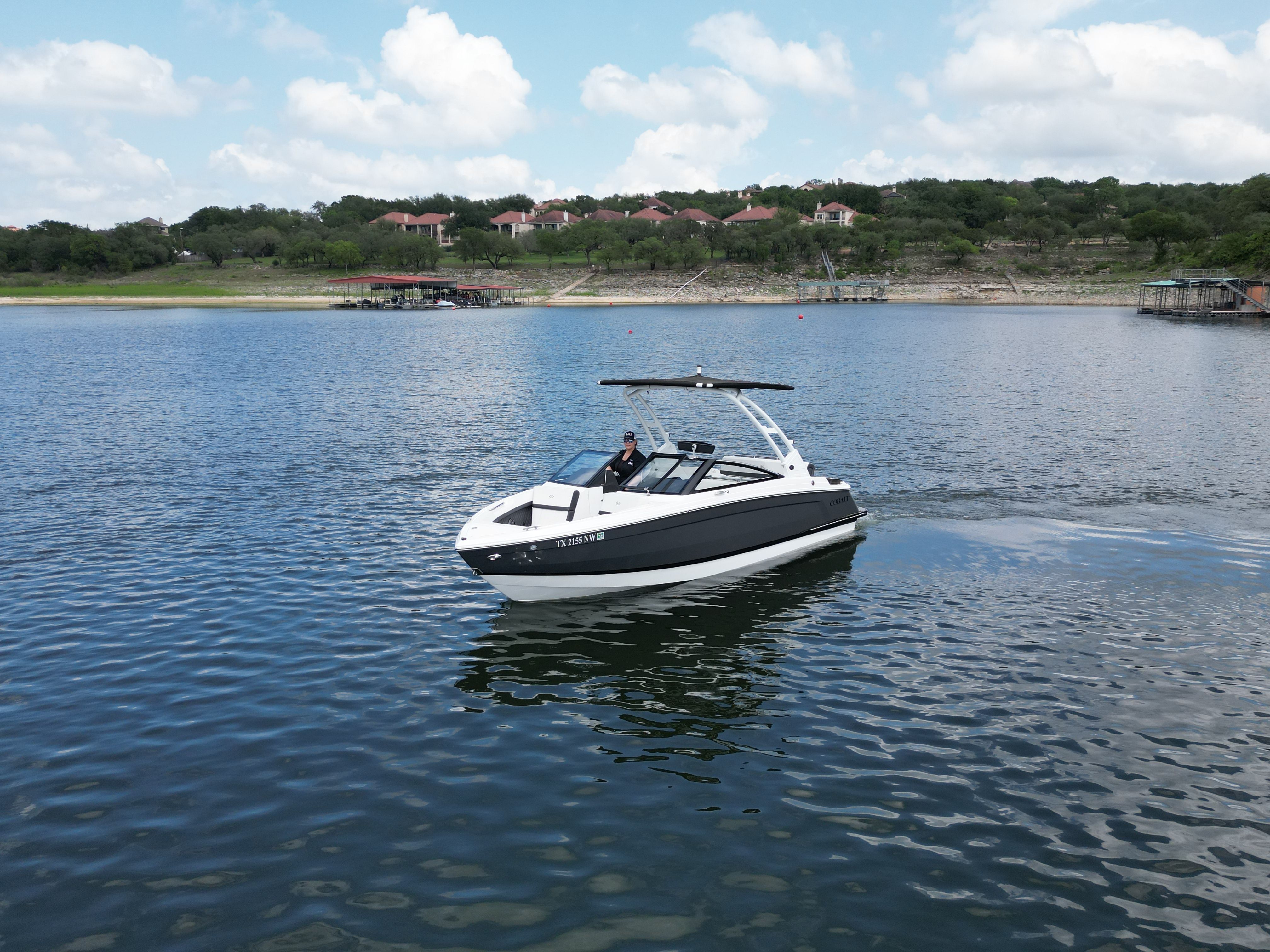 Cobalt R4 2025 boat on a calm lake with cloudy sky.