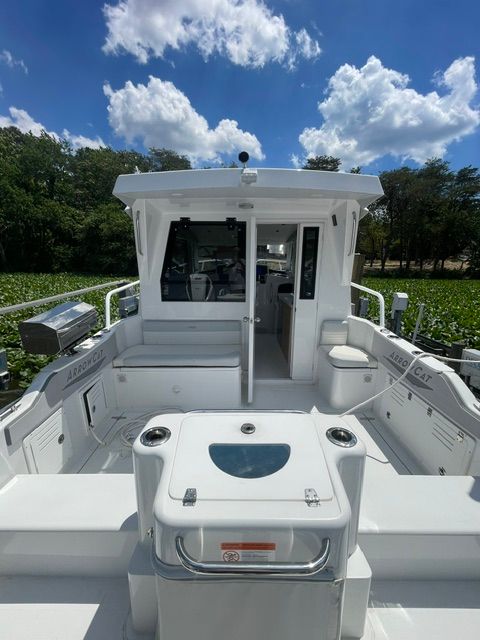 The image shows a modern boat with a spacious deck and a covered cabin.