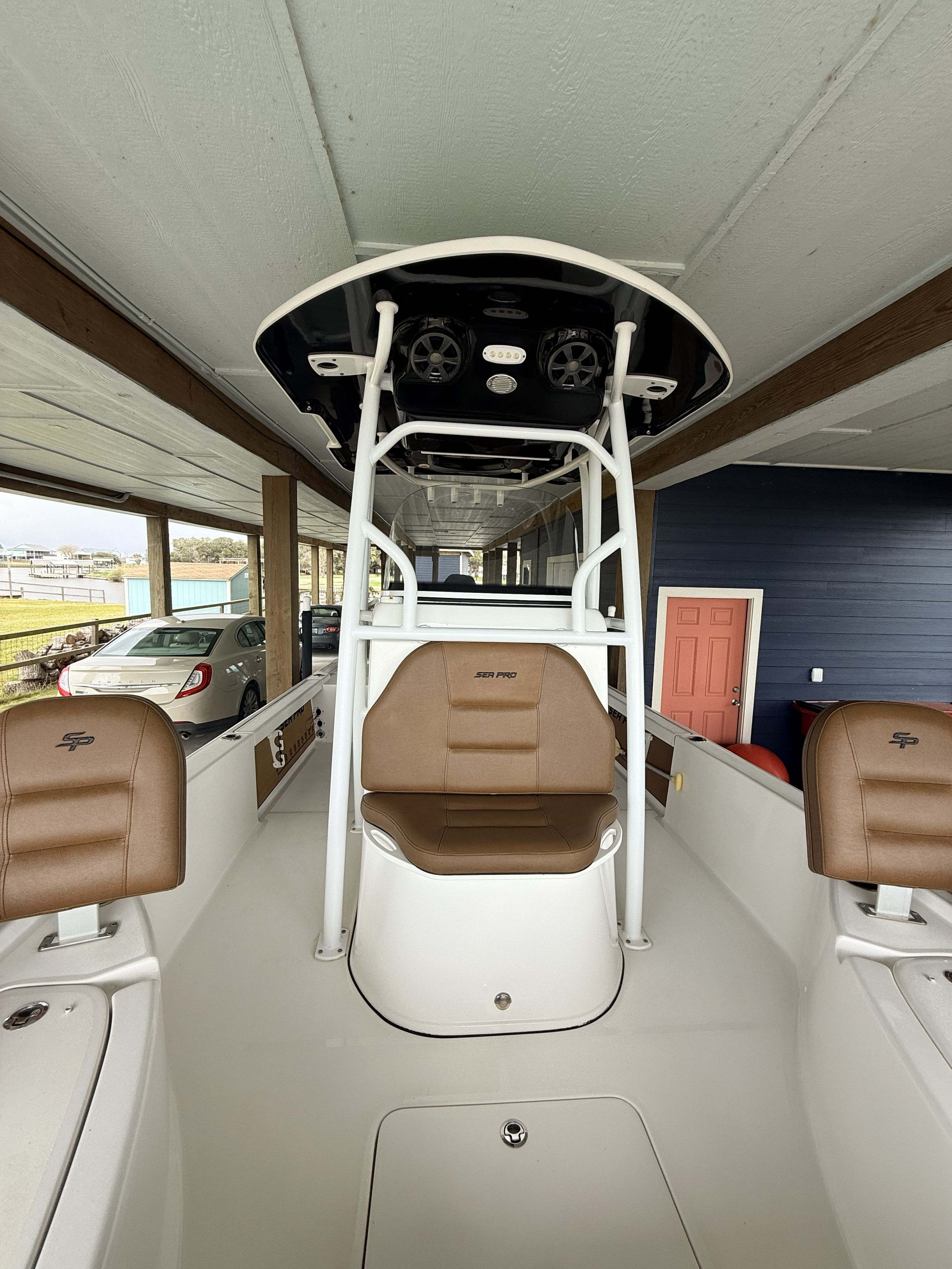 A 2018 Sea Pro 248 Bay boat with brown seats and a white canopy.