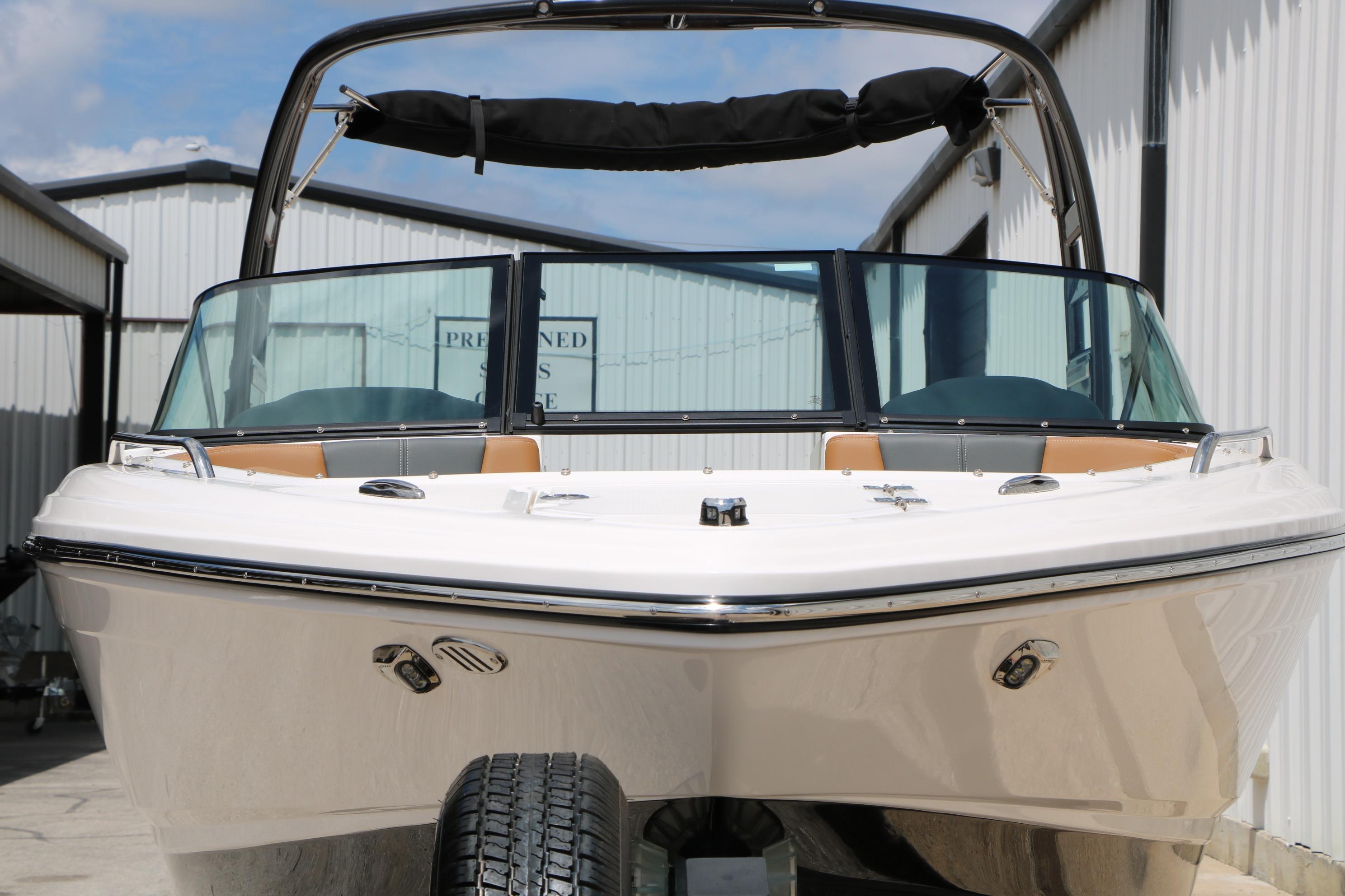 2025 Chaparral 23 SSi boat with sleek design, docked outdoors.