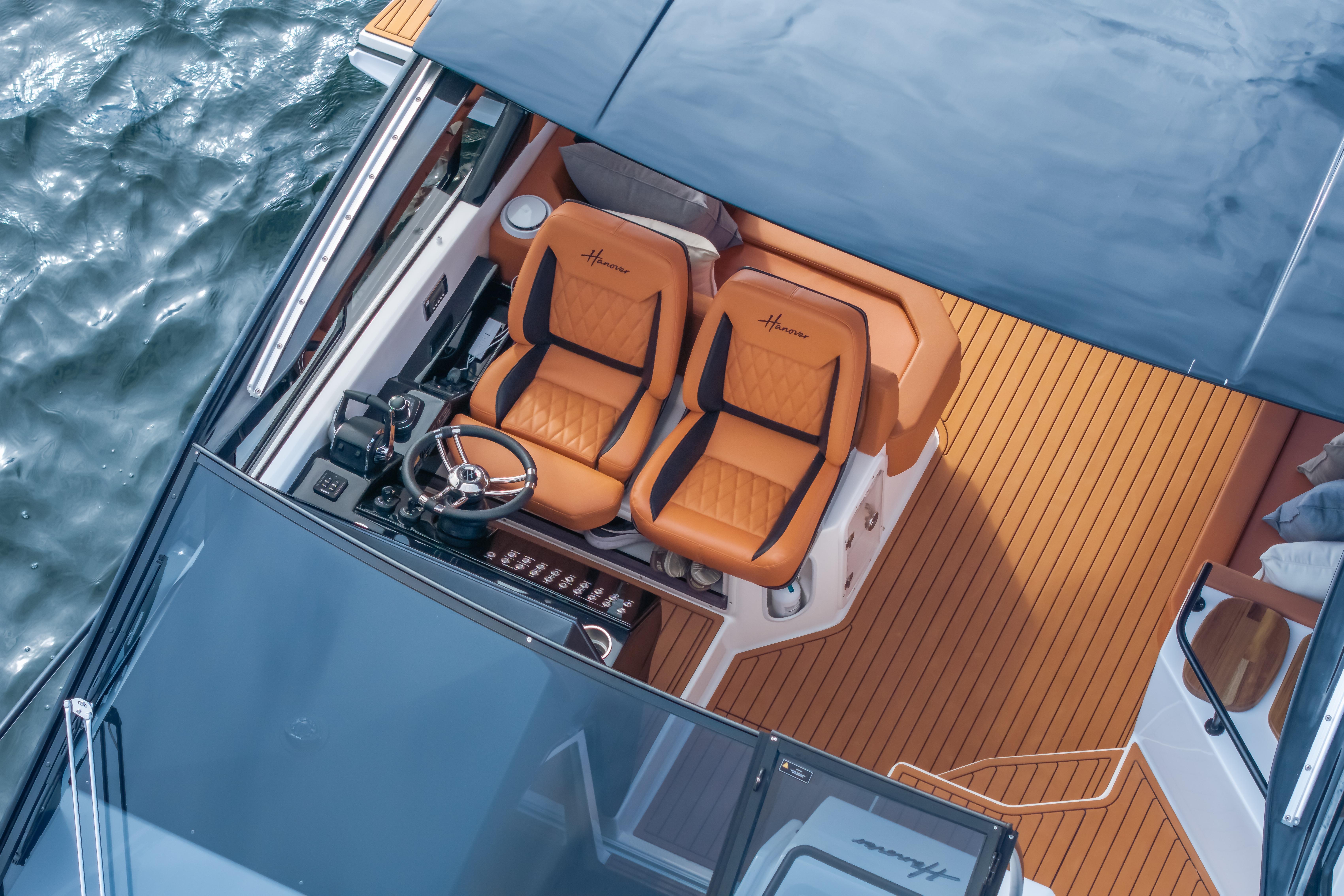 Luxurious Hanover 387 boat interior with leather seats, wooden deck, and steering wheel, 2026 model.