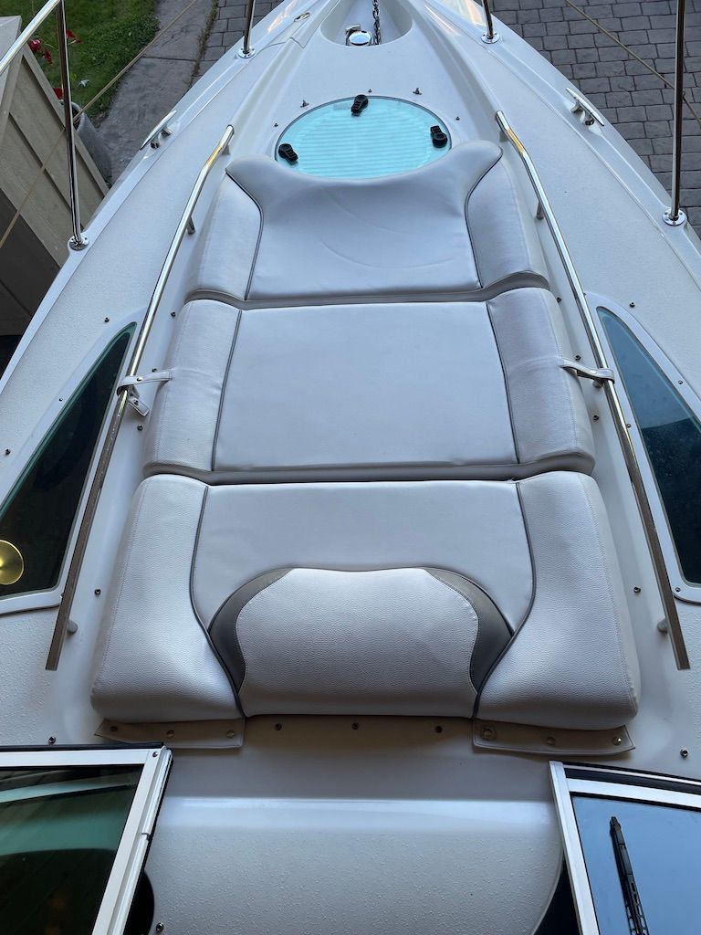 The image shows the foredeck of a Doral Monticello boat with cushioned sun pads.