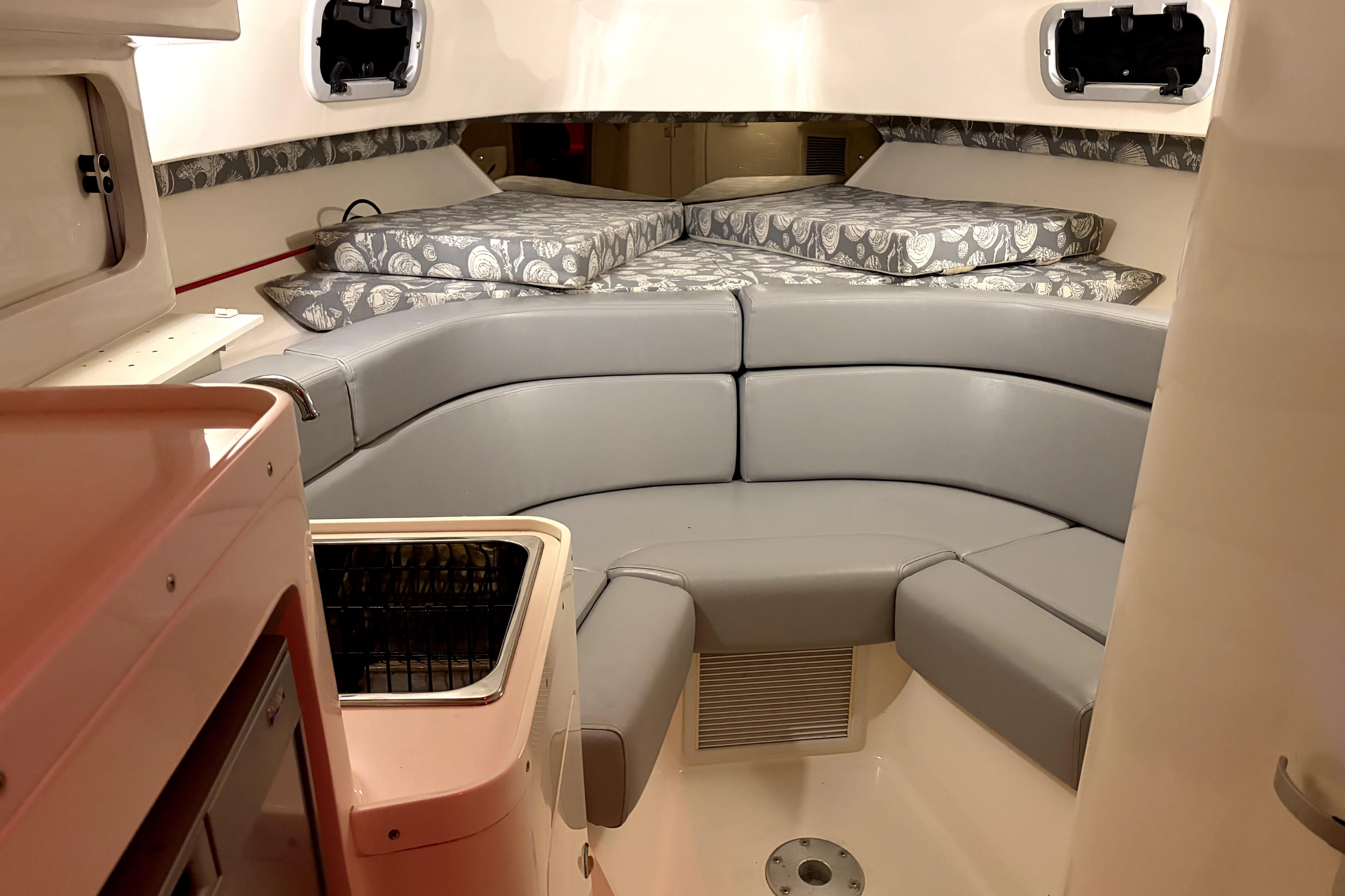 1998 Intrepid 339 Walkaround cabin interior with gray seating and patterned cushions.