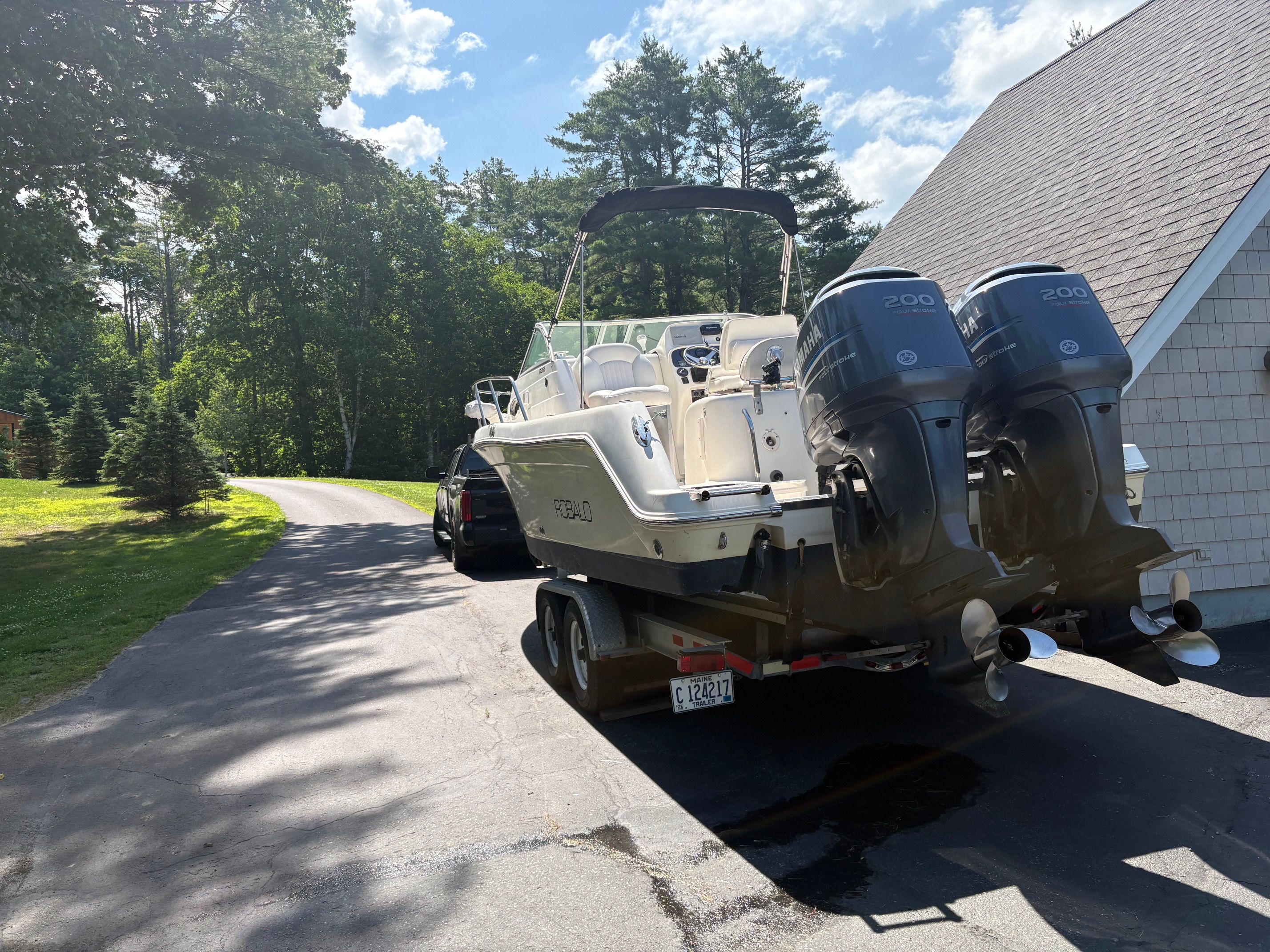 A 2006 Robalo R265 Walkaround boat on a trailer in a driveway.