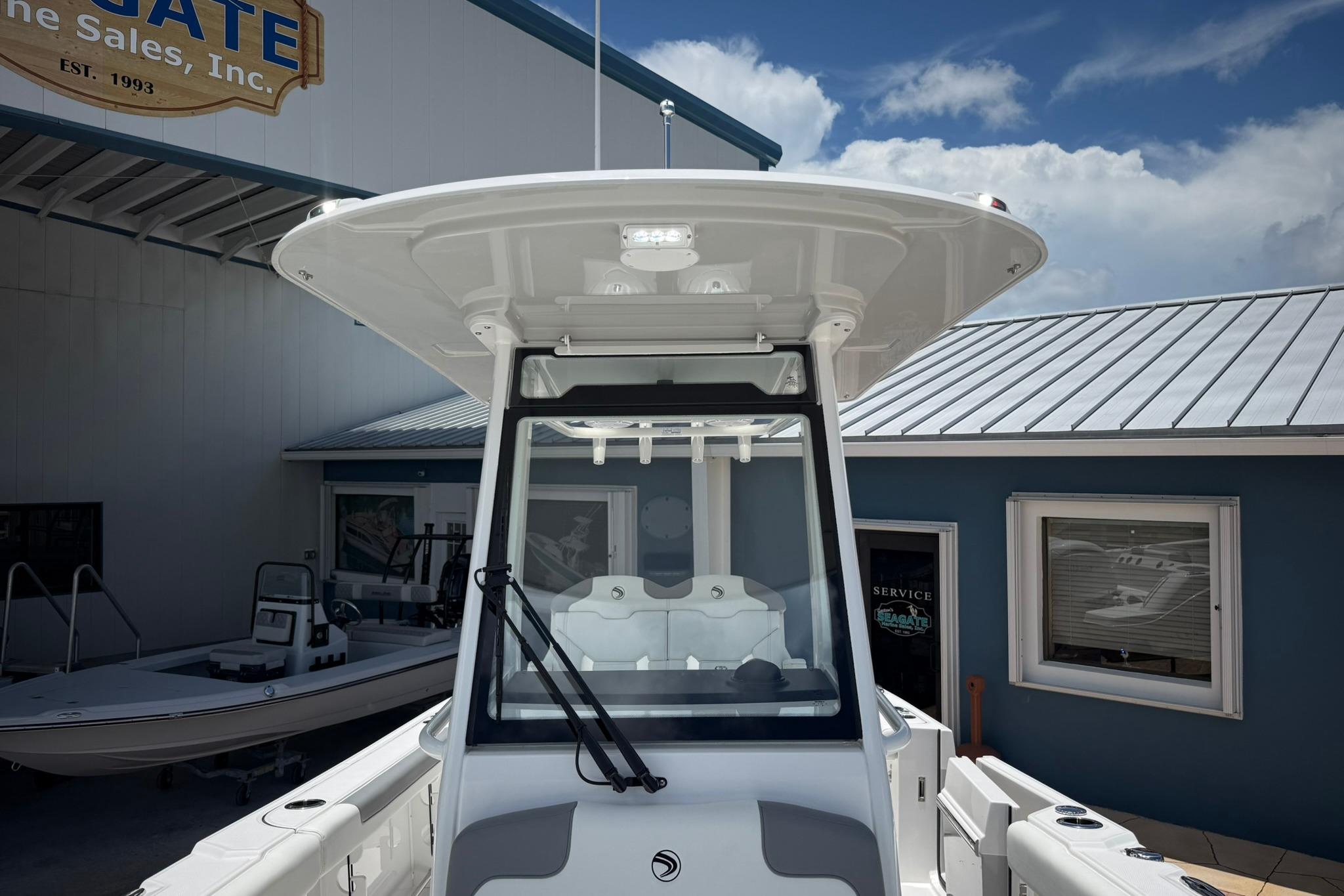 2026 Edgewater 250CC boat displayed at a marine sales facility under a clear sky.