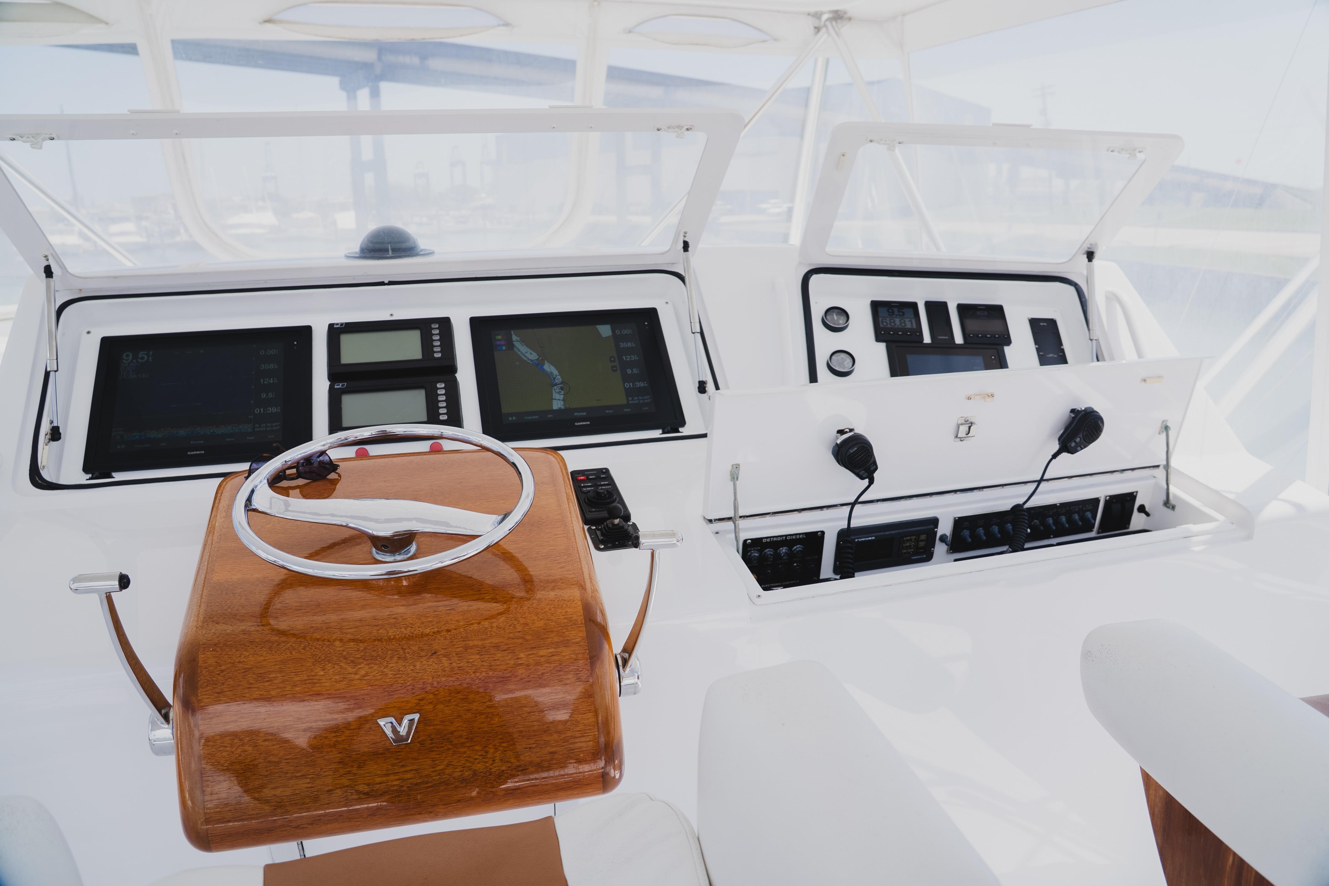 Cockpit of 1999 Viking 58 Convertible yacht with navigation instruments and wooden steering wheel.