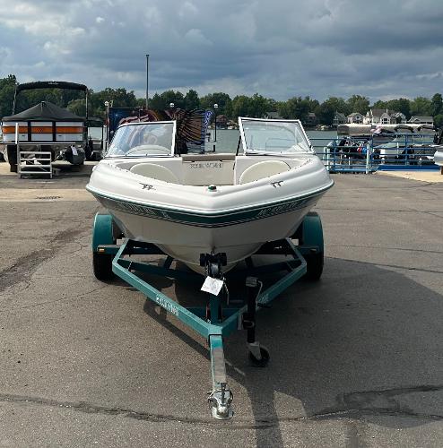 1997 Four Winns Horizon QX boat on trailer, parked at marina.