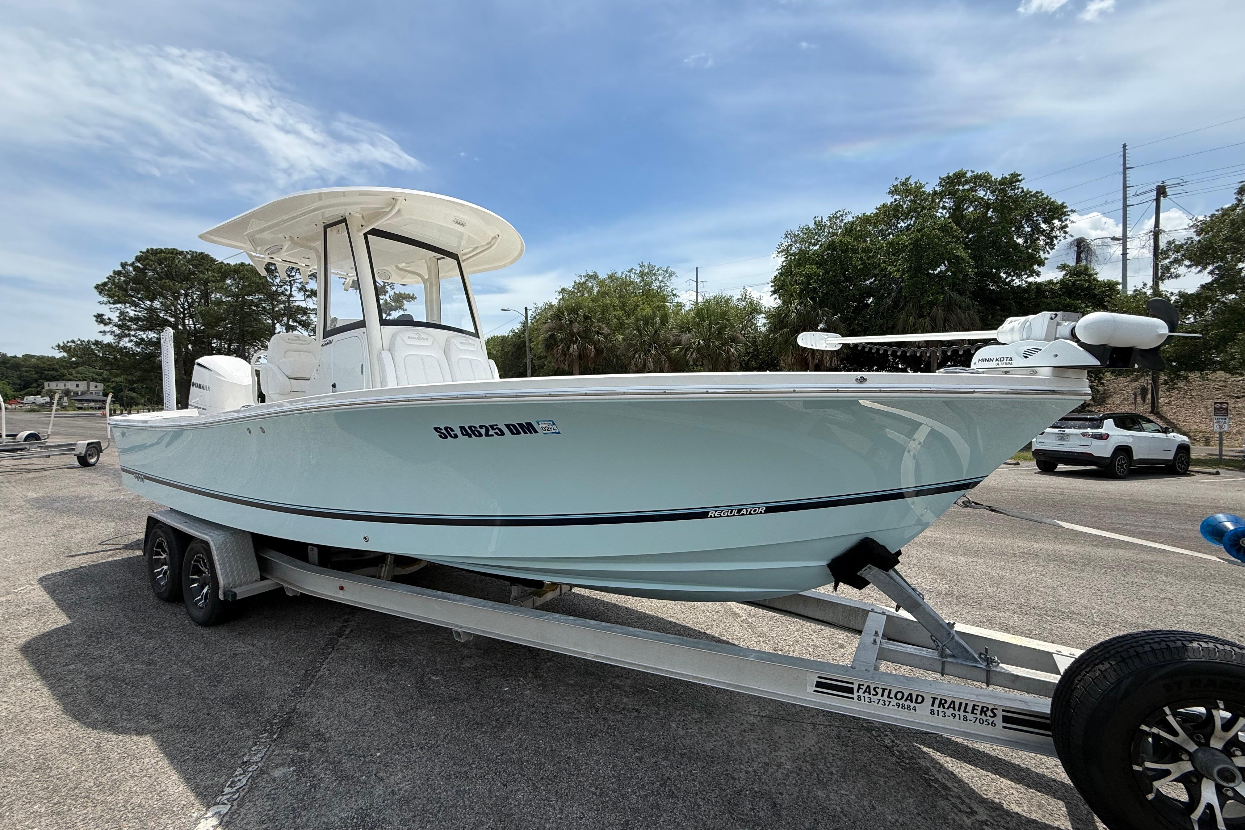 2019 Regulator 26XO boat on trailer, parked outdoors under a clear sky.