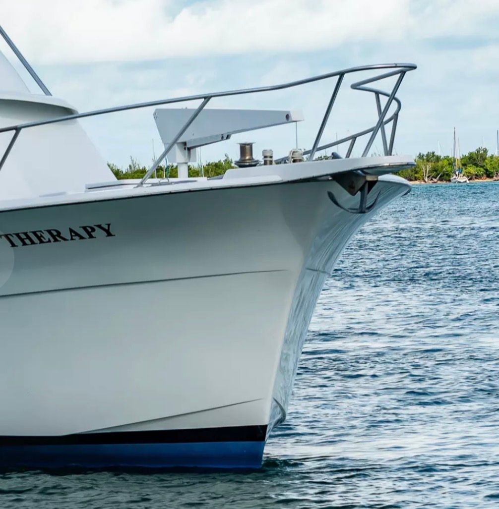 Bow of a 1979 Hatteras sport fishing boat on calm water.