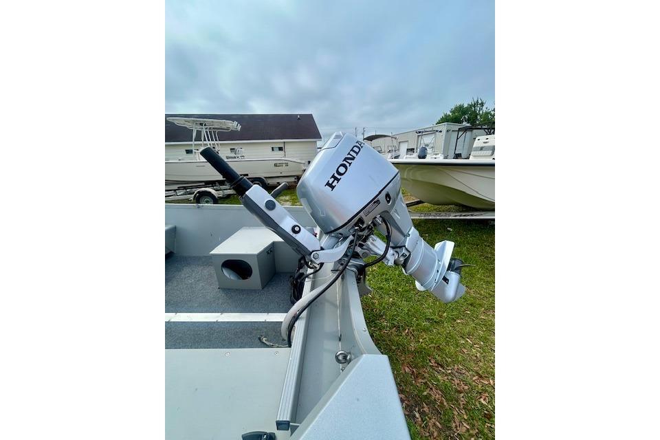 2022 Alumacraft V16 boat with Honda outboard motor, parked on grass.