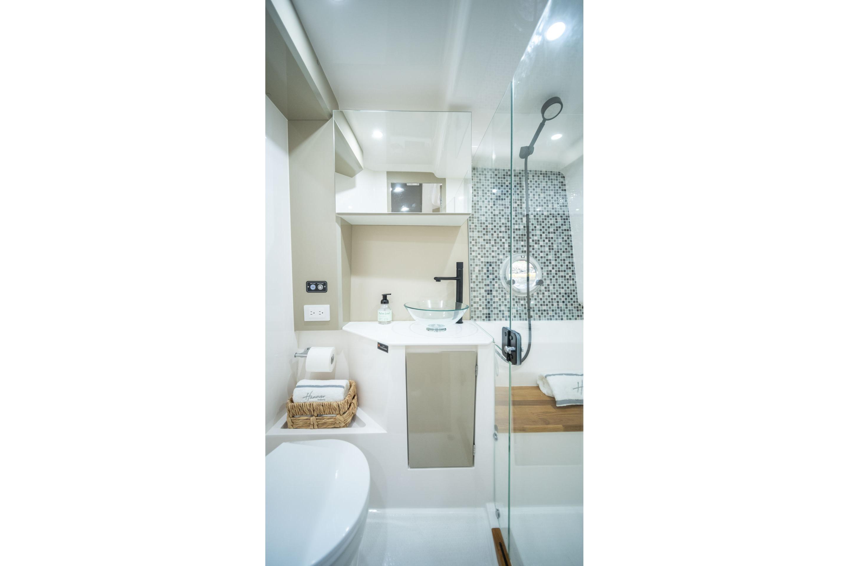 Modern bathroom in 2026 Hanover 387 yacht with glass shower and sleek fixtures.